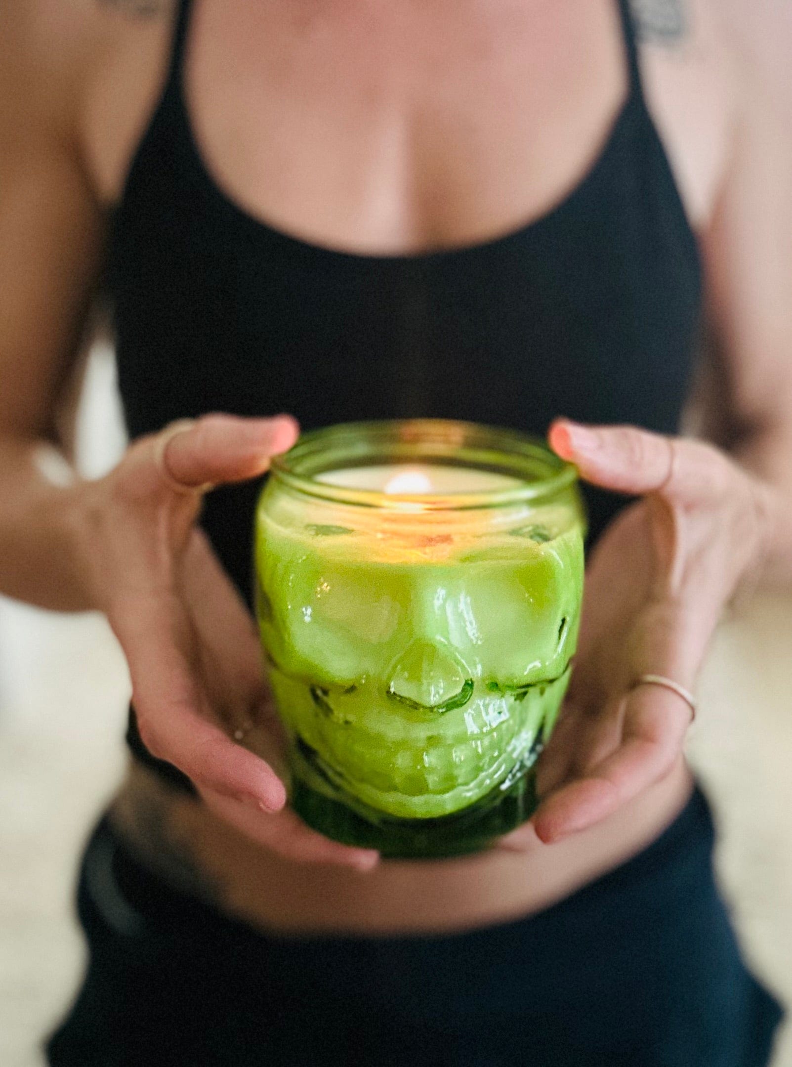 Lit green skull candle made with 100% recycled glass and wooden wick