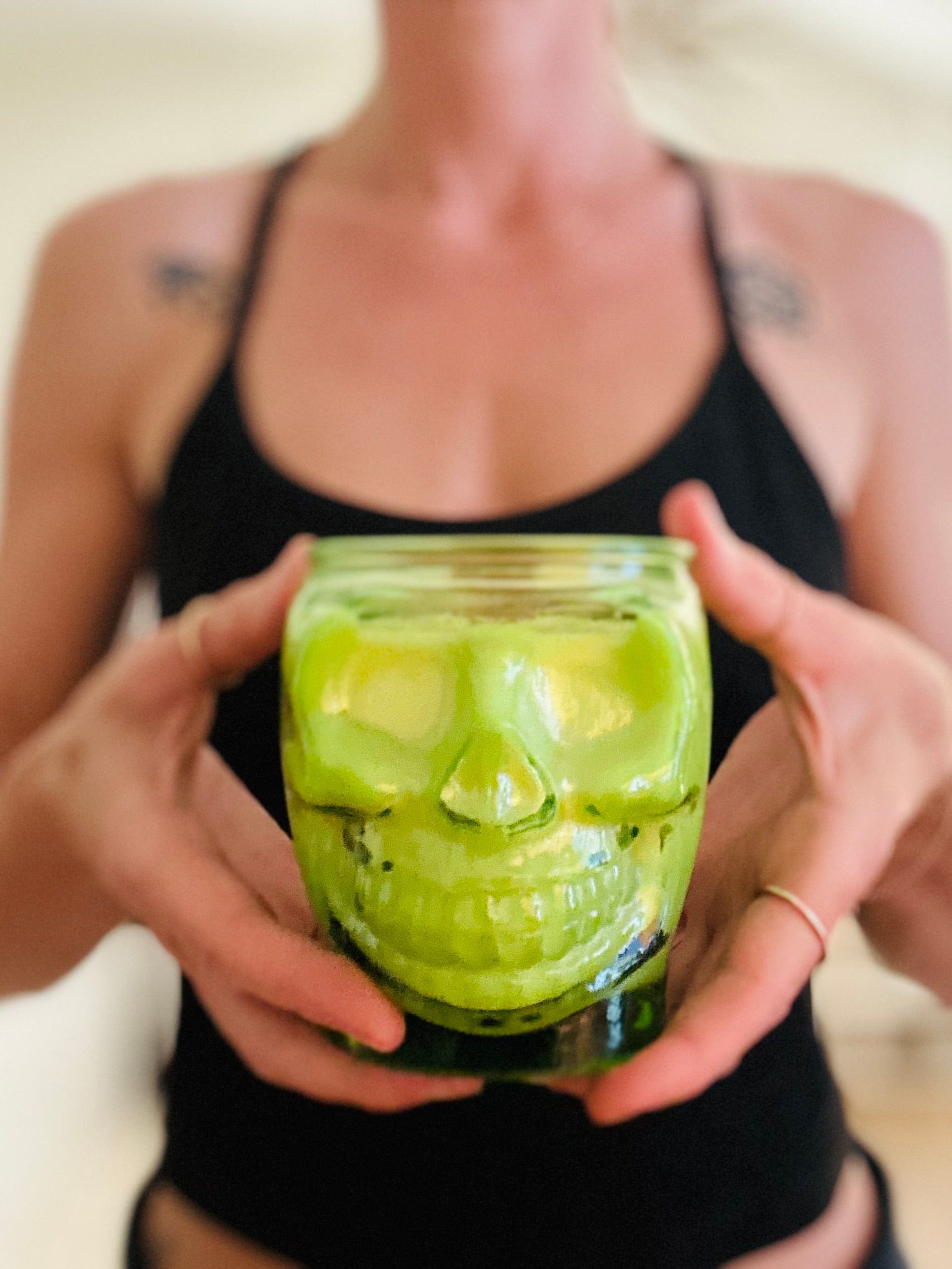 Neon green skull candles lit in hands scented with rosemary and sage, and some spice