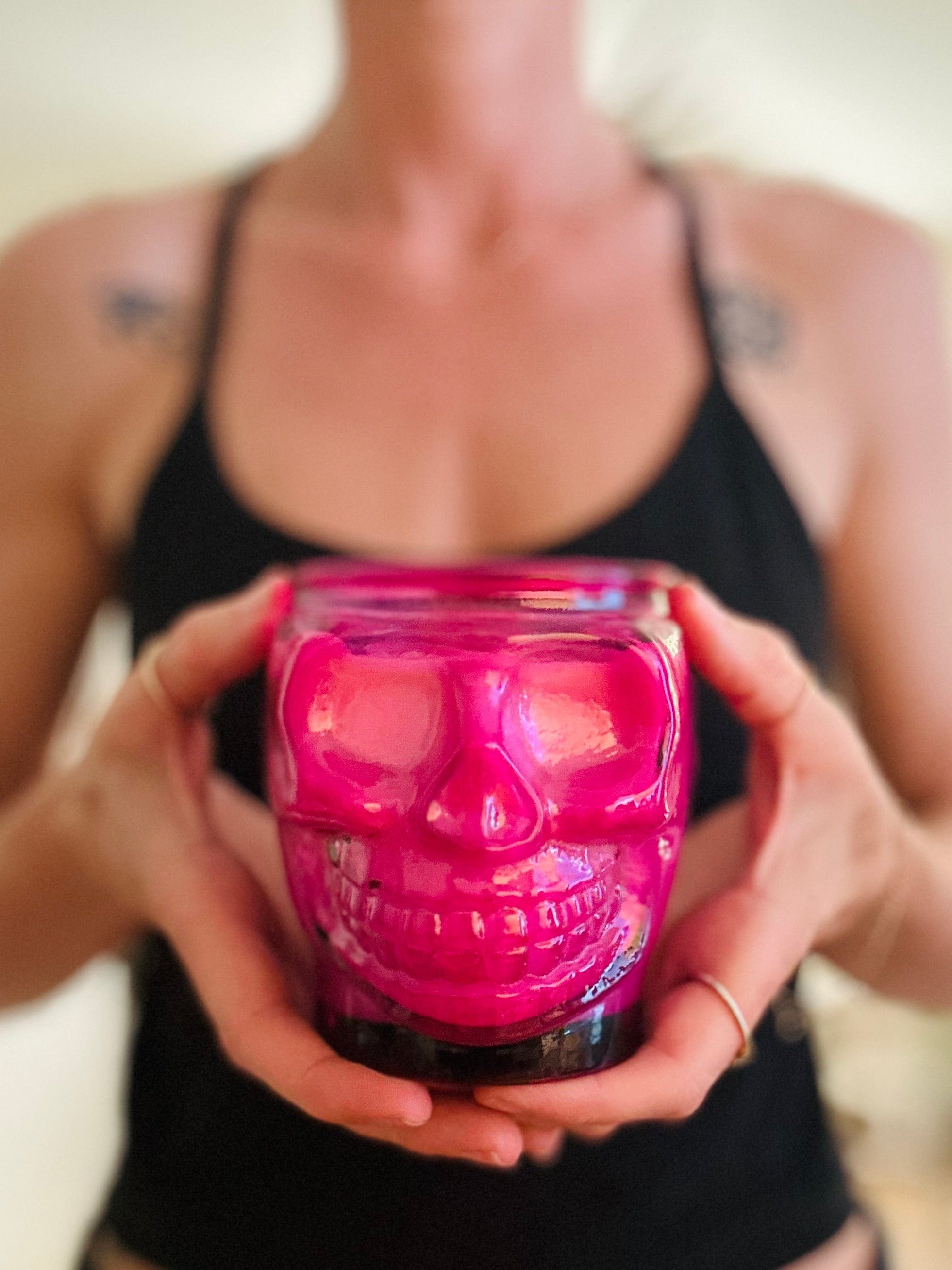 Pink skull candle in hands ready for the ritual