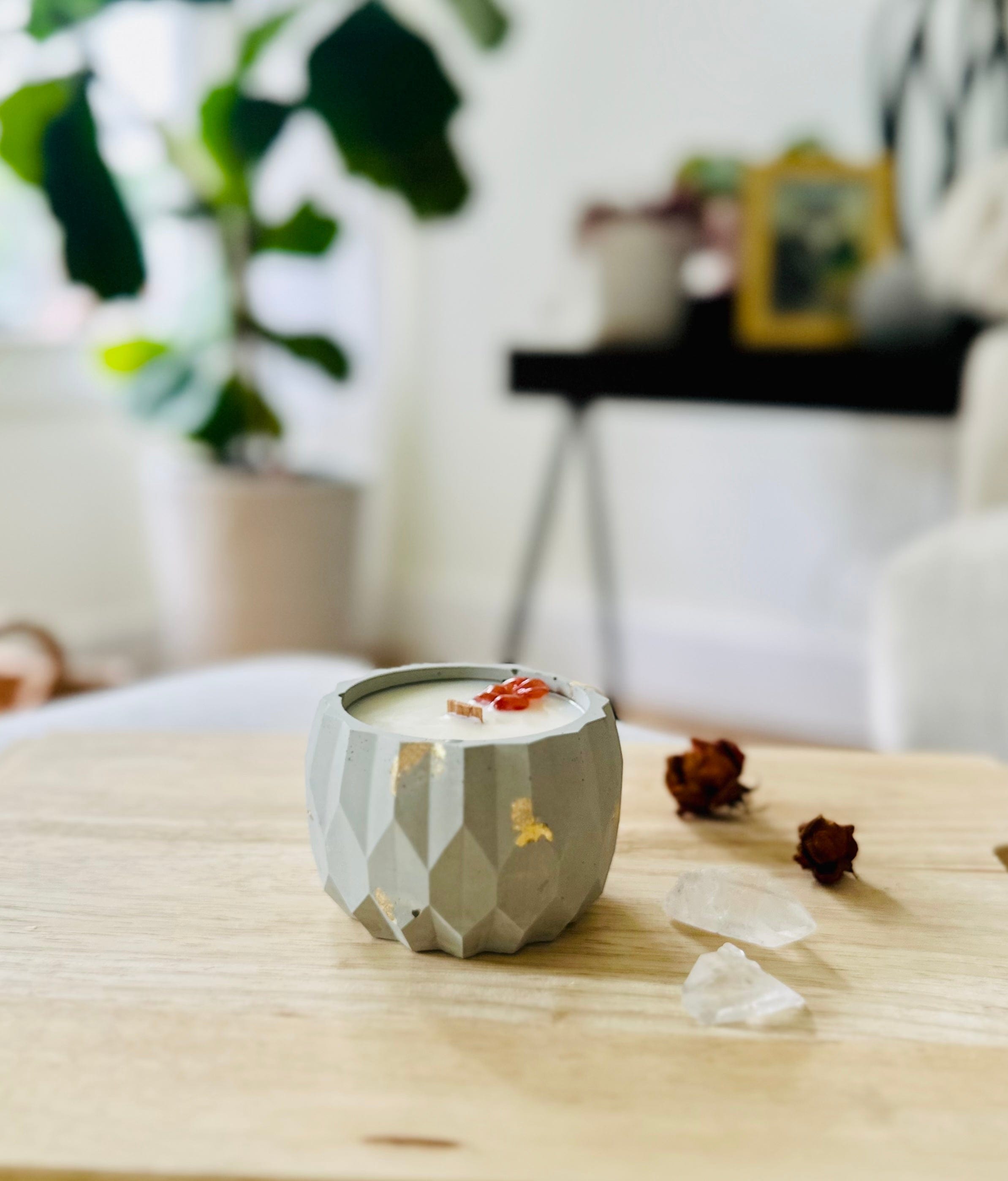Textured cement candle with gold flecks and crystal accent, surrounded by natural light and calming tones.