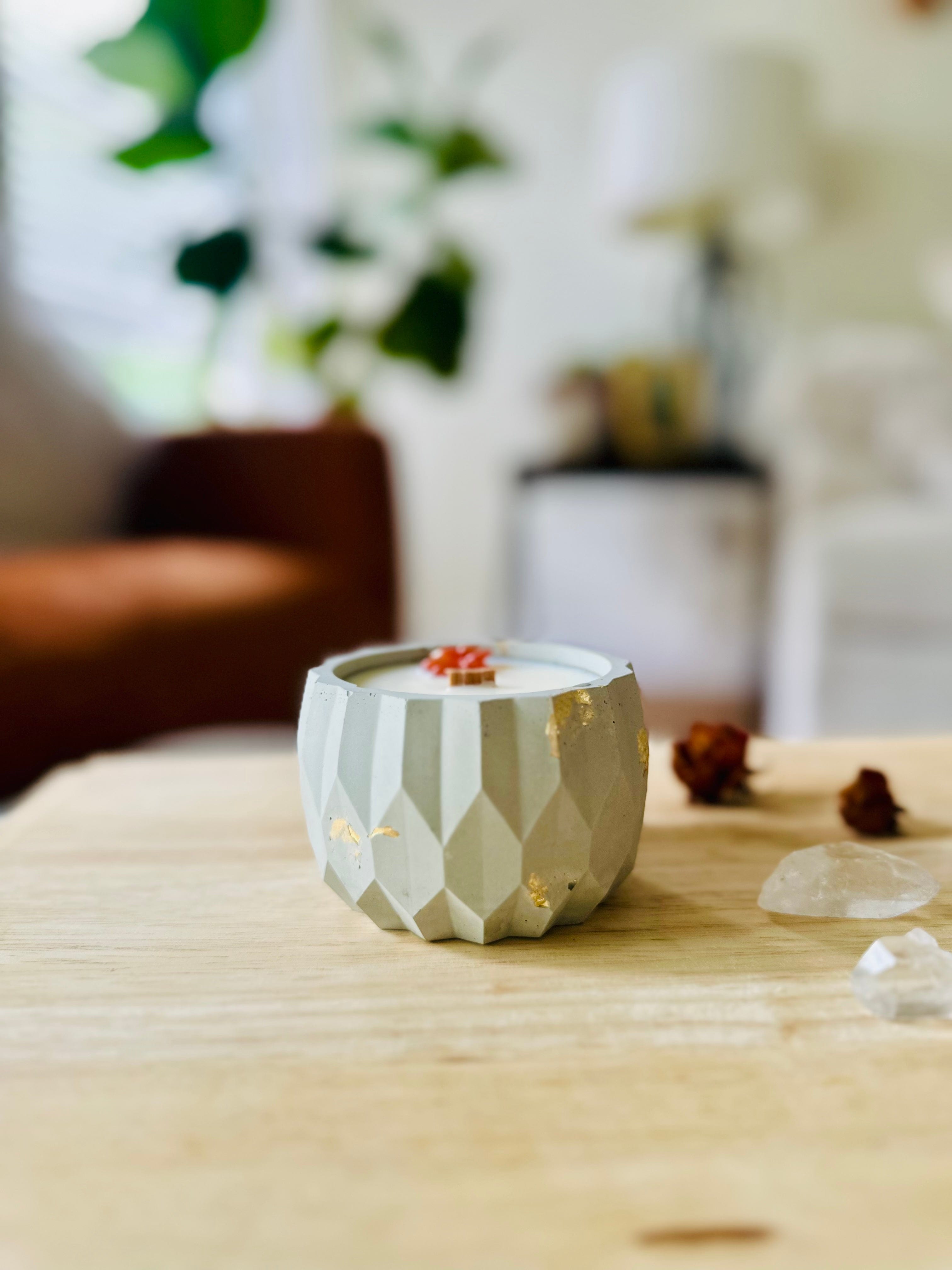 Top-down view of coconut candle in textured cement vessel