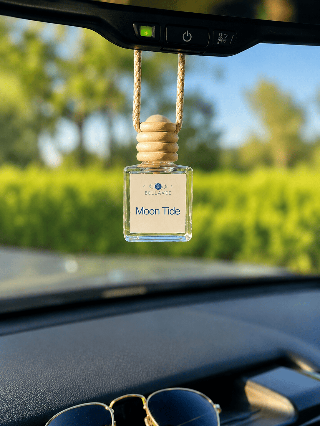 BellaVee Moon Tide car diffuser hanging from a rearview mirror with ocean air, nag champa, and coconut fragrance. Handcrafted non-toxic car air freshener infused with moonstone for calm, balance, and intentional living.