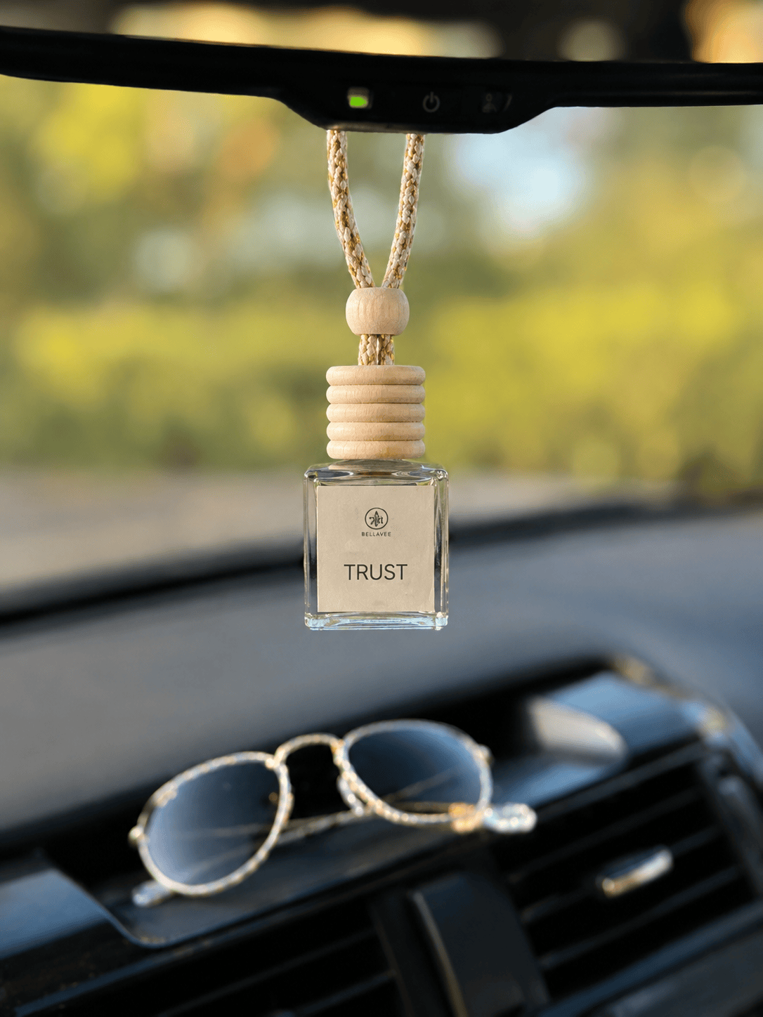 White Oak and Vanilla non-toxic car diffuser by BellaVee, hanging from rearview mirror