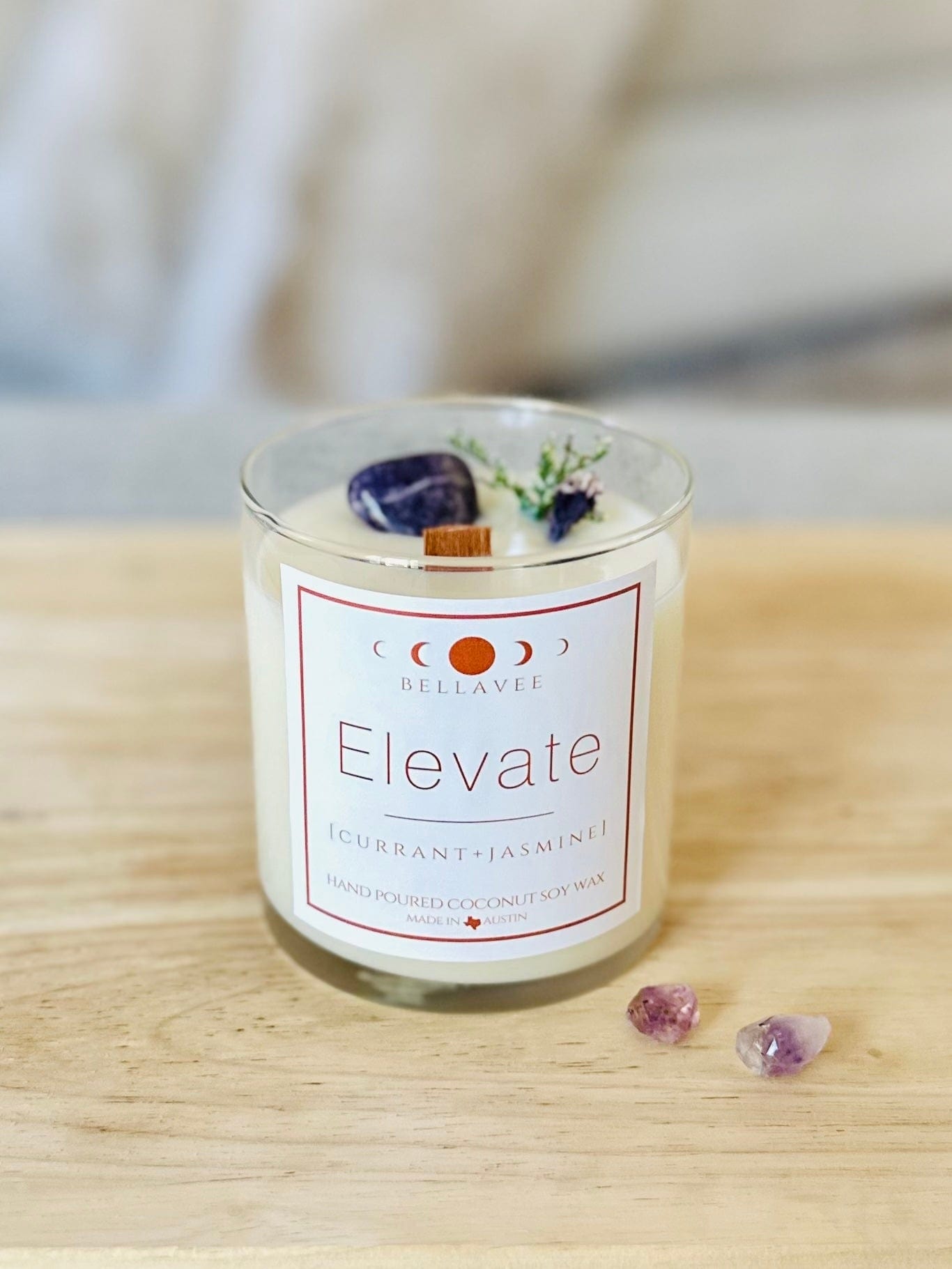 Elevate Amethyst Crystal candle with dried botanicals and small amethyst chunks surrounding it.