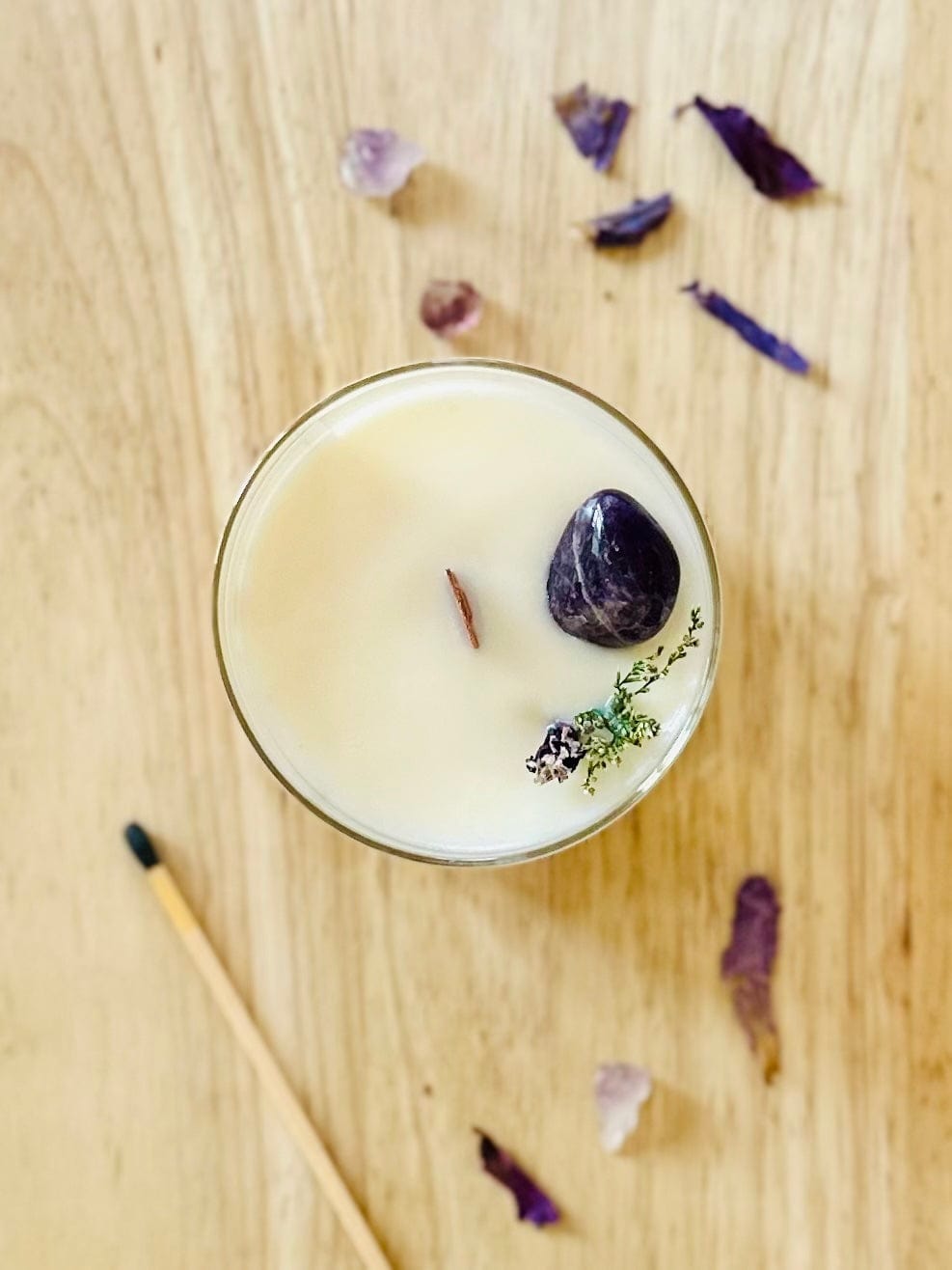 Top view of Elevate Amethyst crystal candle with match stick and crystals surrounding it