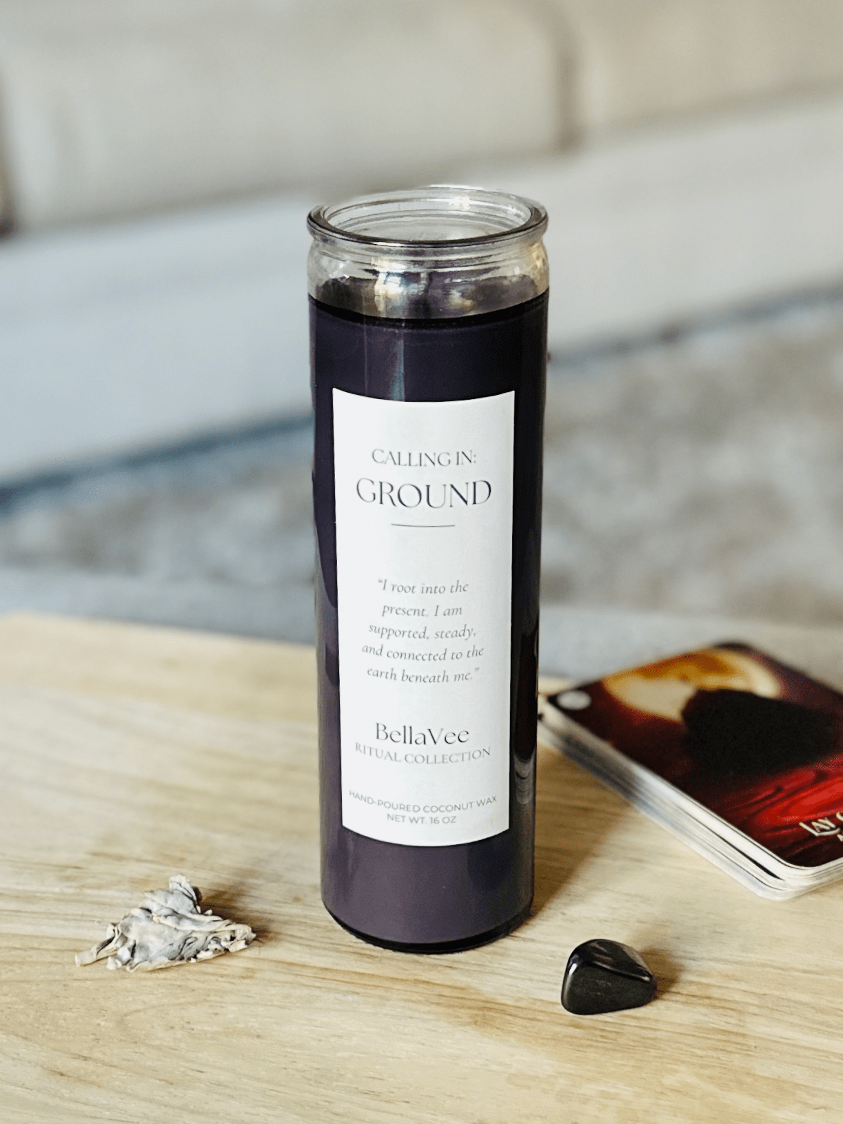 Calling In: Ground Candle on a wooden surface with black grounding crystal and cozy background