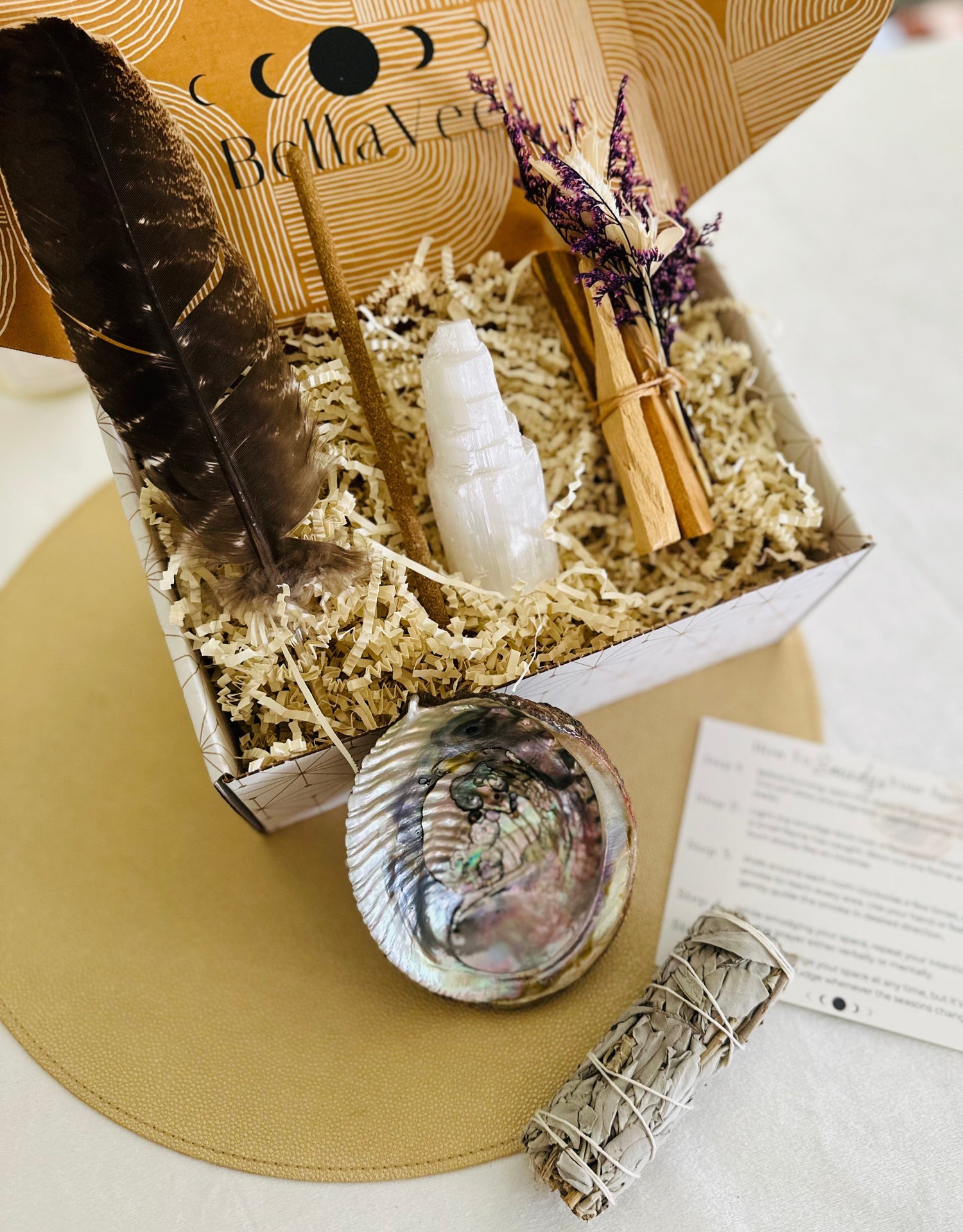 Smudge Kit comes with a feather, shimmering abalone shell, selenite tower, Palo Santo incense, and your choice of sage or Palo Santo