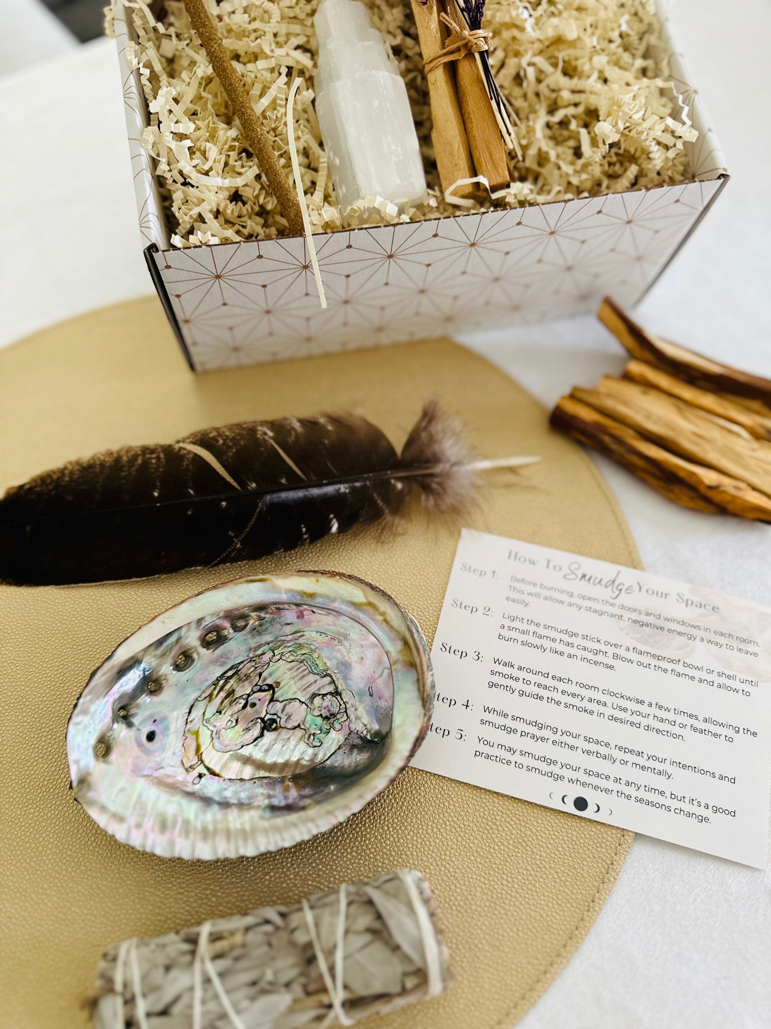 Smudge Kit with a feather, selenite tower, abalone shell, hand-rolled Palo Santo incense, detailed smudge guide, and sage or Palo Santo