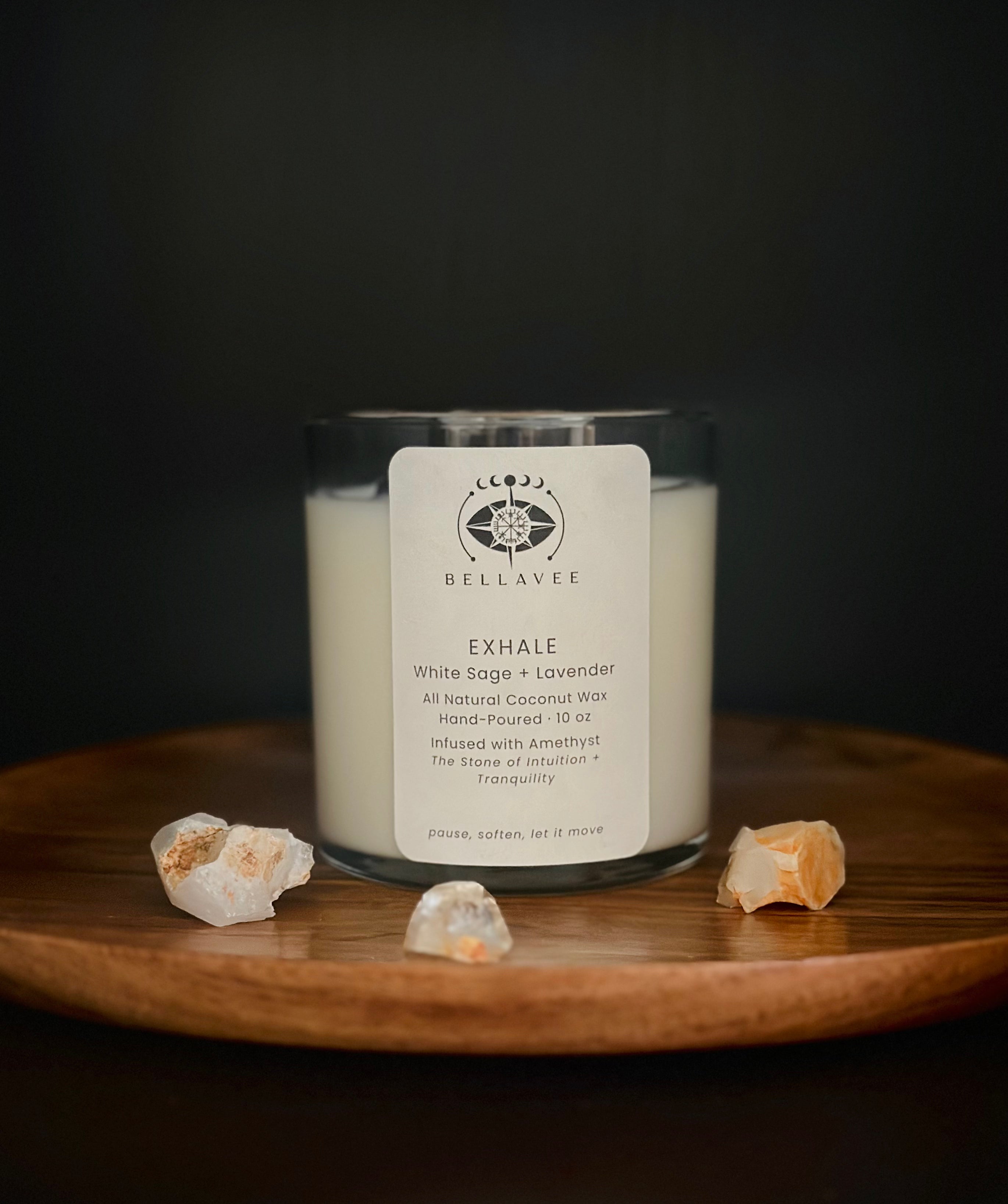 Exhale Amethyst crystal ritual candle in a glass vessel on a wooden tray with a calm, neutral setting.