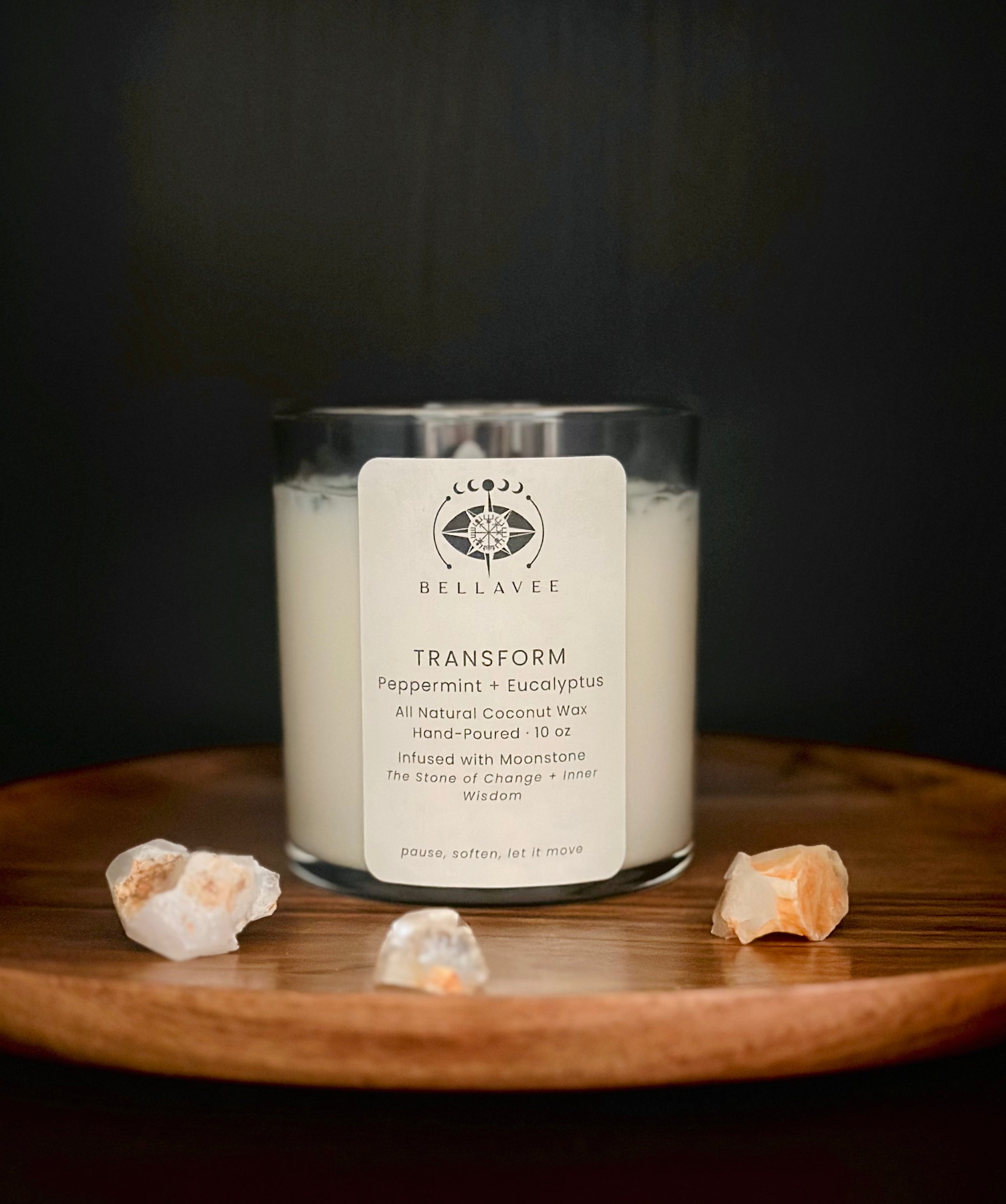 Transform Moonstone crystal ritual candle in a clear glass jar styled with natural elements.