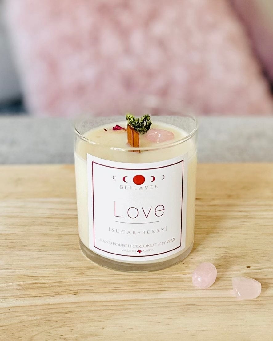 Love Rose Quartz Crystal Candle with two rose quartz tumbles on the side. with dried botanicals and wooden wick