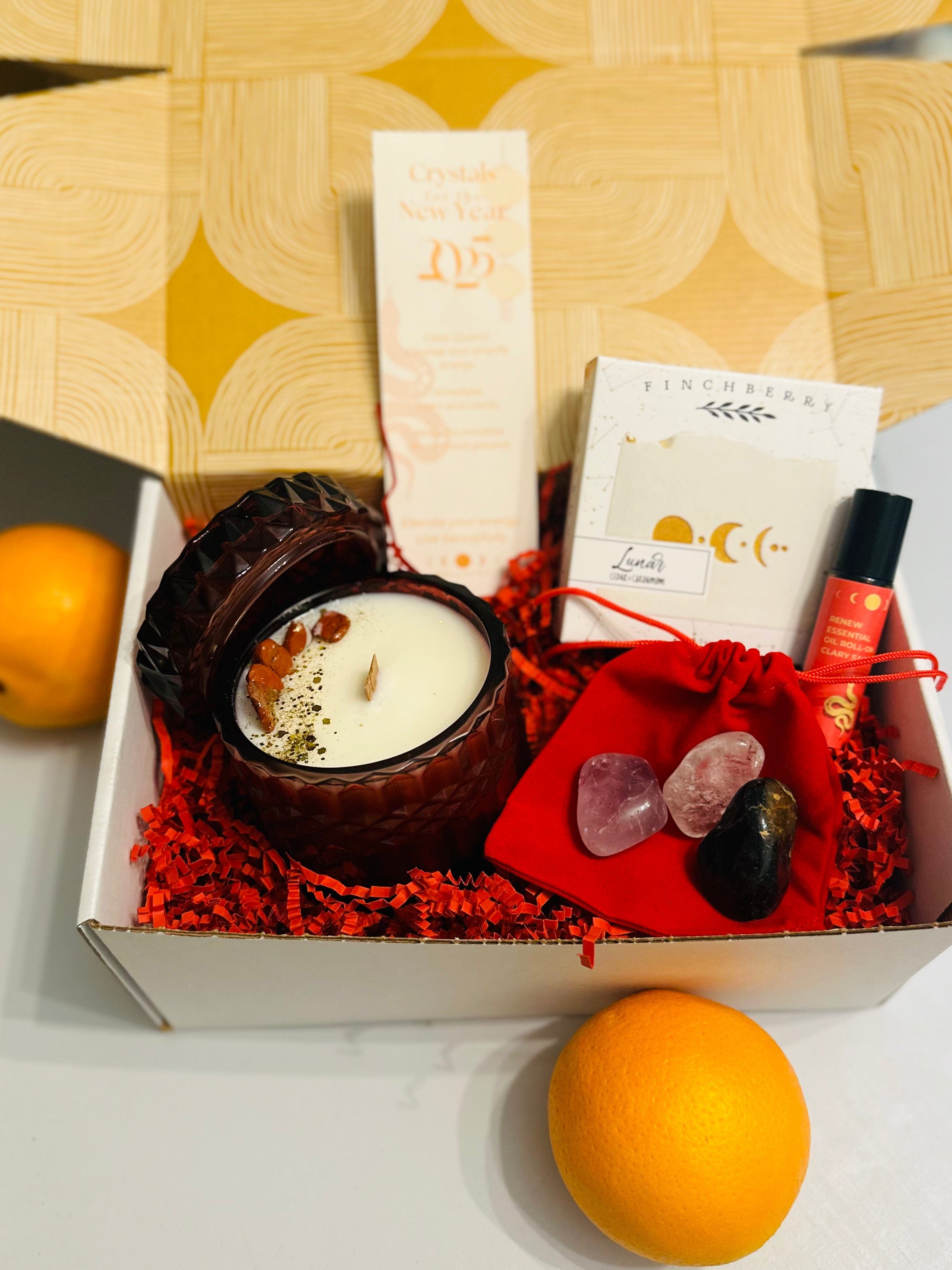 Lunar New Year Year of the Snake Gift Box with Snake Candle, Clary Sage Essential Oil Roll-On, and 2025 Crystal Bookmark in a red velvet bag.