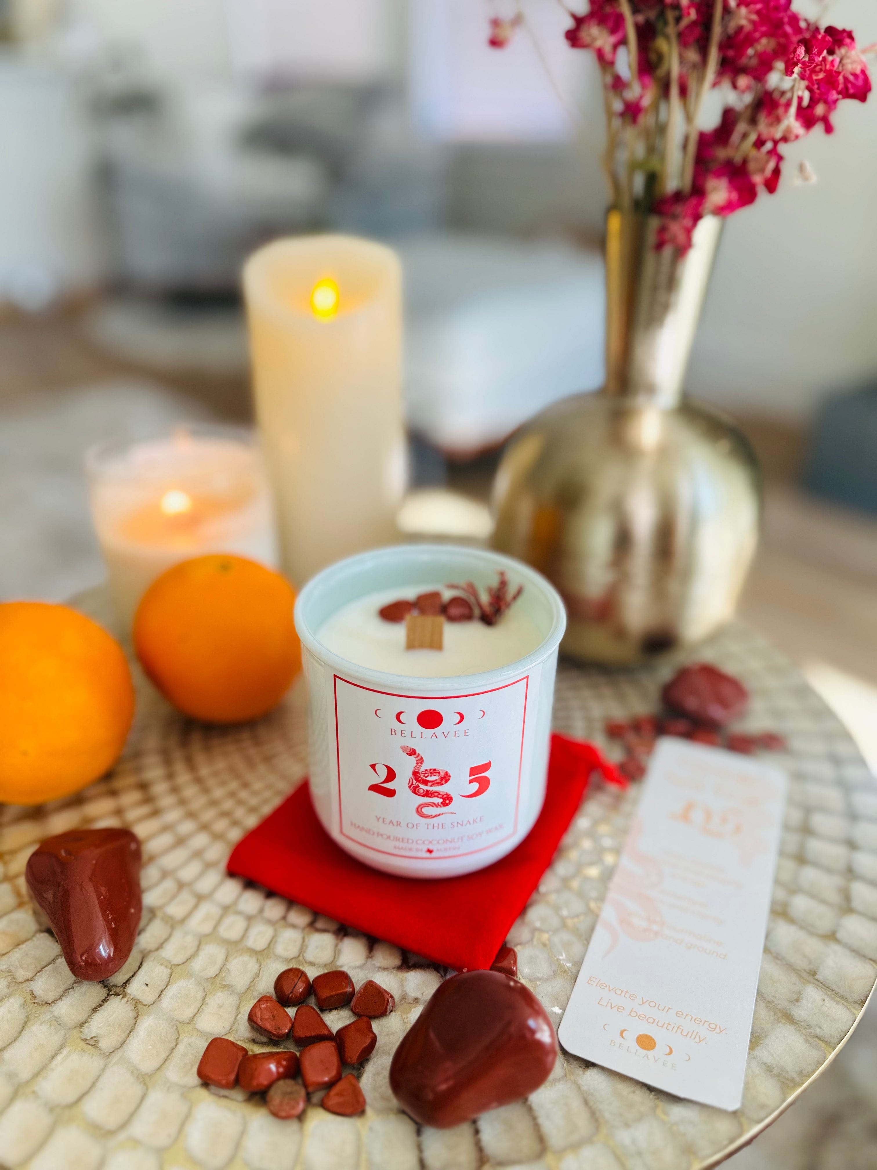 Year of the Snake Candle with Red Jasper stones, Palo Santo, and Sandalwood scents in a 100% recycled glass vessel.