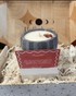Candle in a decorative container with a card in front on a patterned surface
BellaVee MMCC subscription candle with monthly ritual tools and handwritten message