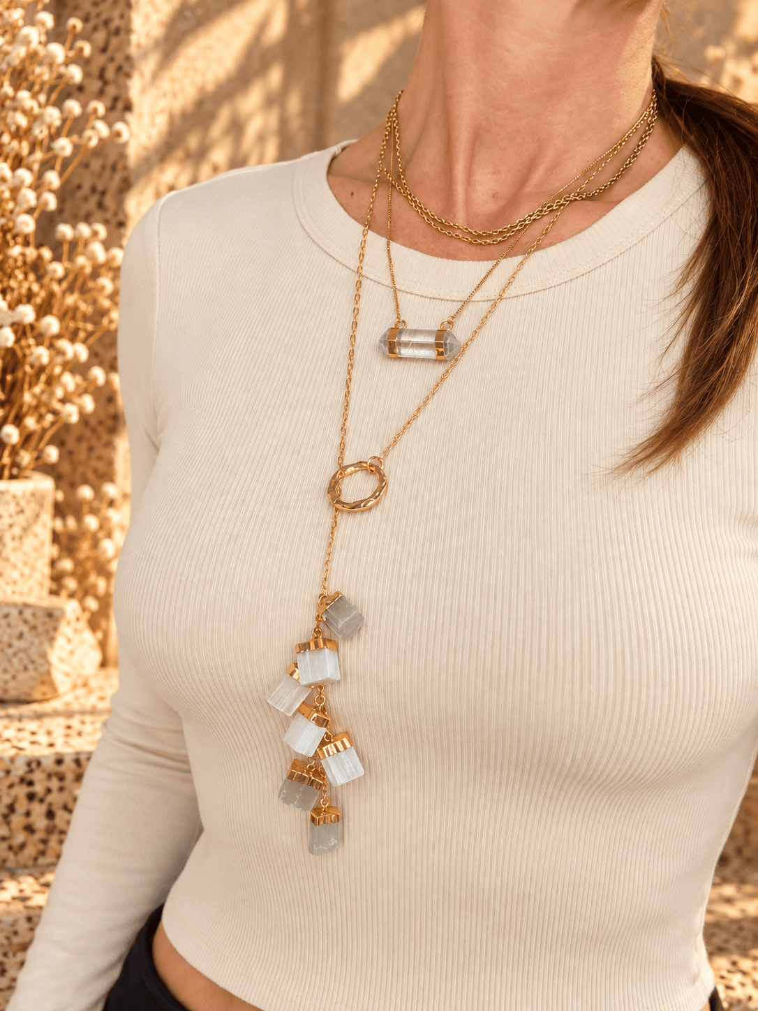 Clear Quartz double-terminated bar necklace worn in a layered gold crystal necklace stack