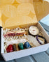 Crystal Wellness Gift Box with Blue Lapis, Green Aventurine, Brown Jasper, Red Jasper, Selenite Tower, Palo Santo bundle, mini crystal candle, and Amethyst bracelet.