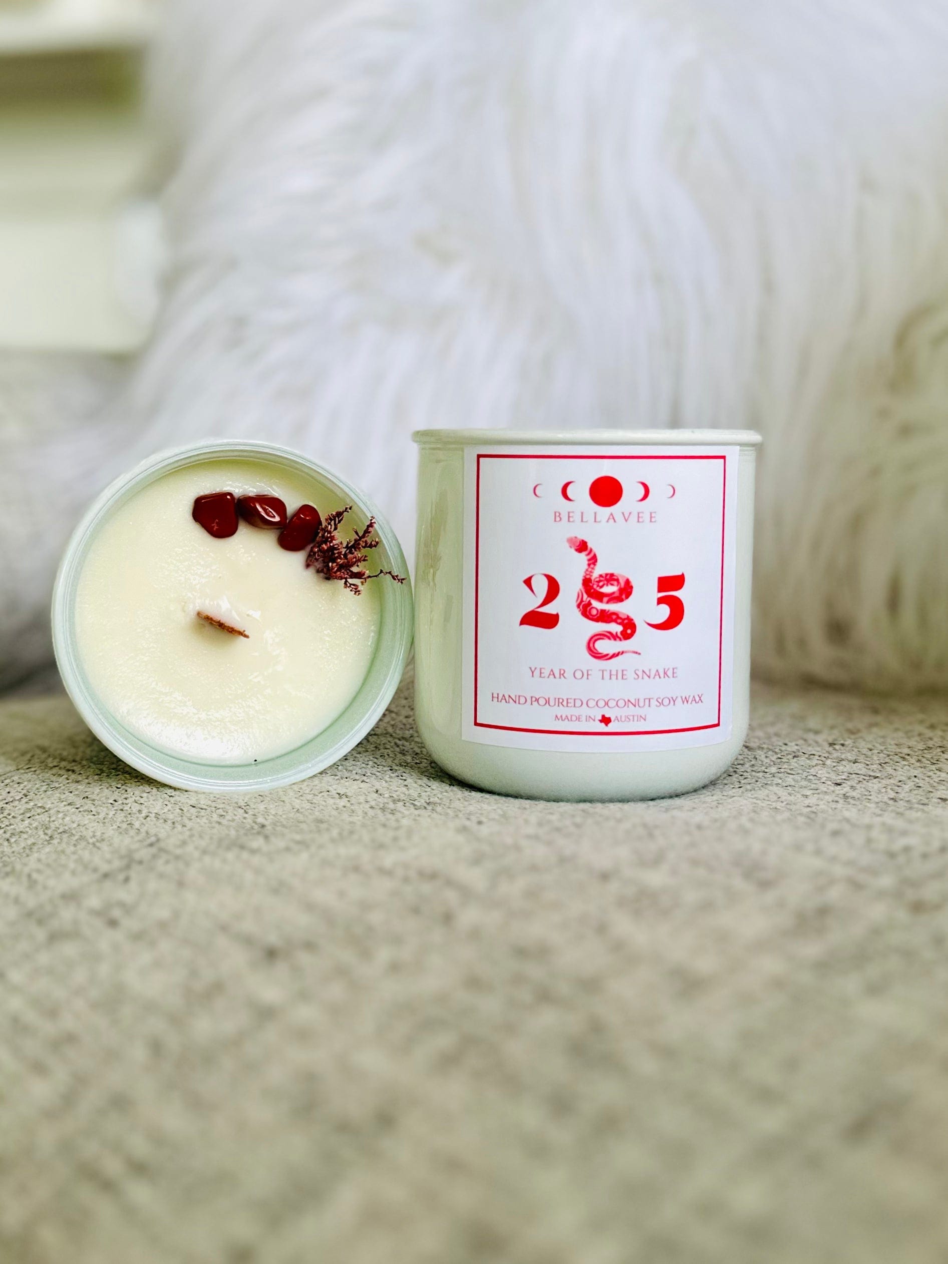 10 oz Year of the Snake Candle featuring Red Jasper stones, over 80 hours of burn time, and a peaceful Palo Santo and Sandalwood blend.