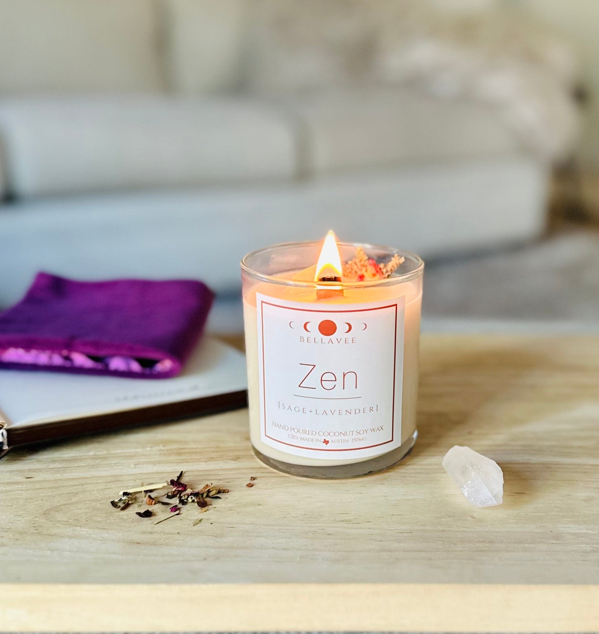 Lit Zen CBD Crystal Candle glowing with warm light, placed on a tabletop next to clear quartz and wellness items, evoking a calming aromatherapy ritual.