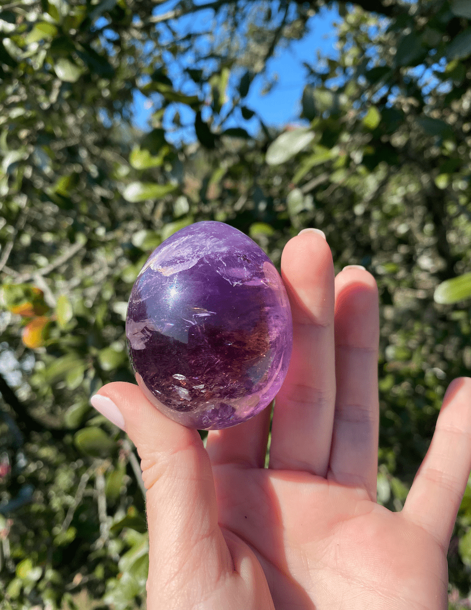 Polished Brazilian Amethyst egg, known for activating spiritual awareness and enhancing intuition with its vibrant purple hue