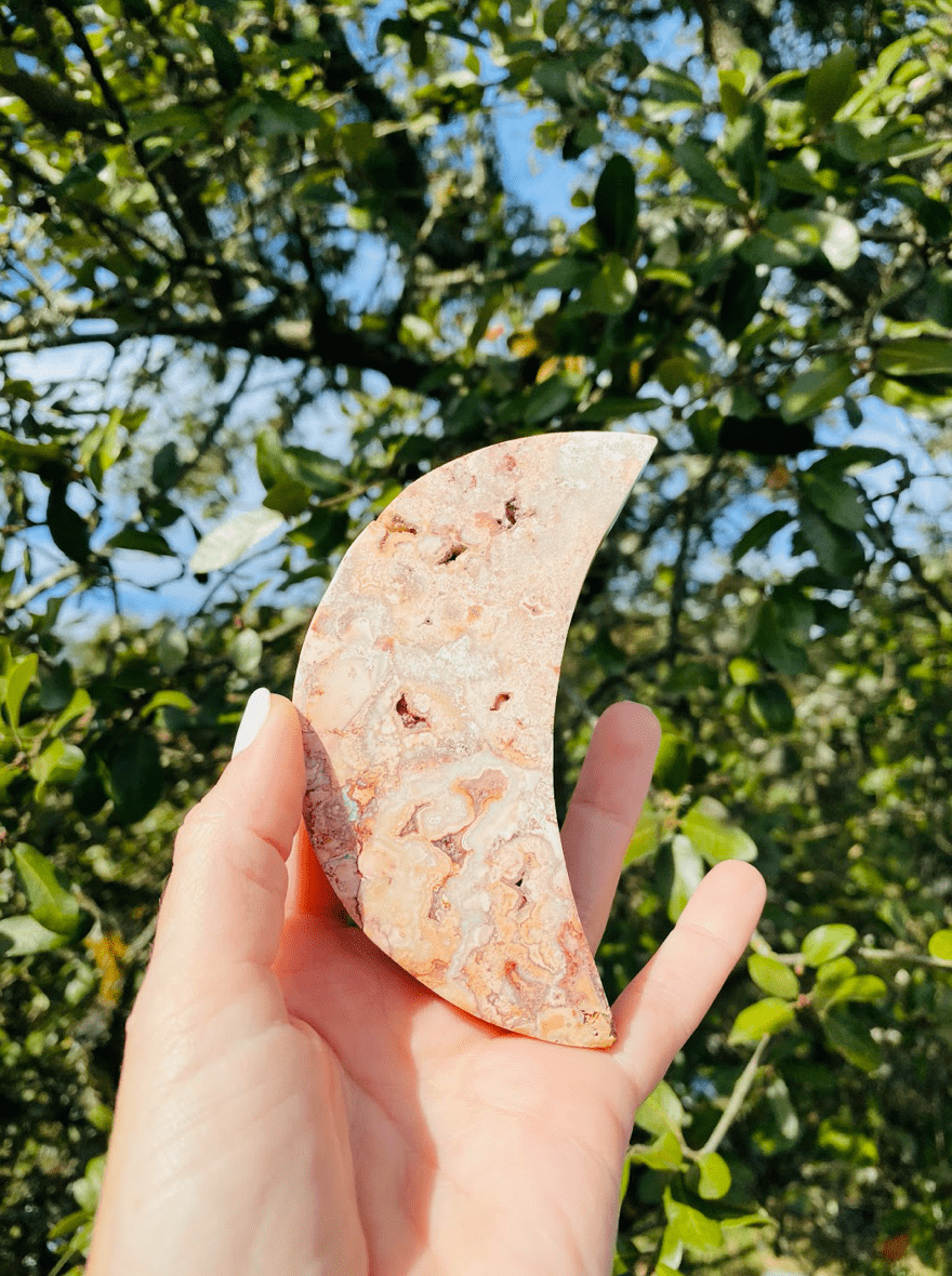 Held high, the Sliced Agate Crescent Moon shines with earthy hues, symbolizing balance, protection, and natural beauty