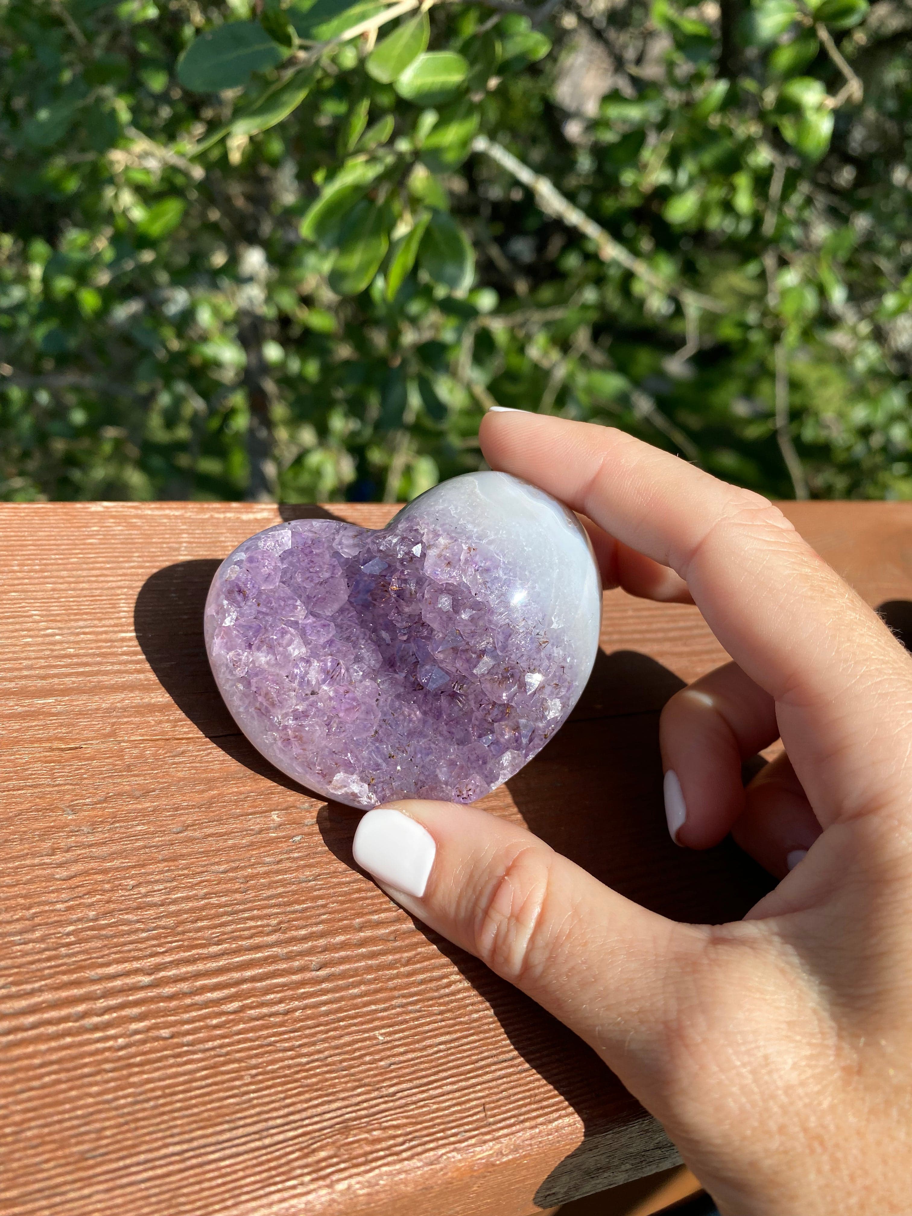 Amethyst and baby blue Agate heart glistening in the sunlight, offering protection and energy balance.