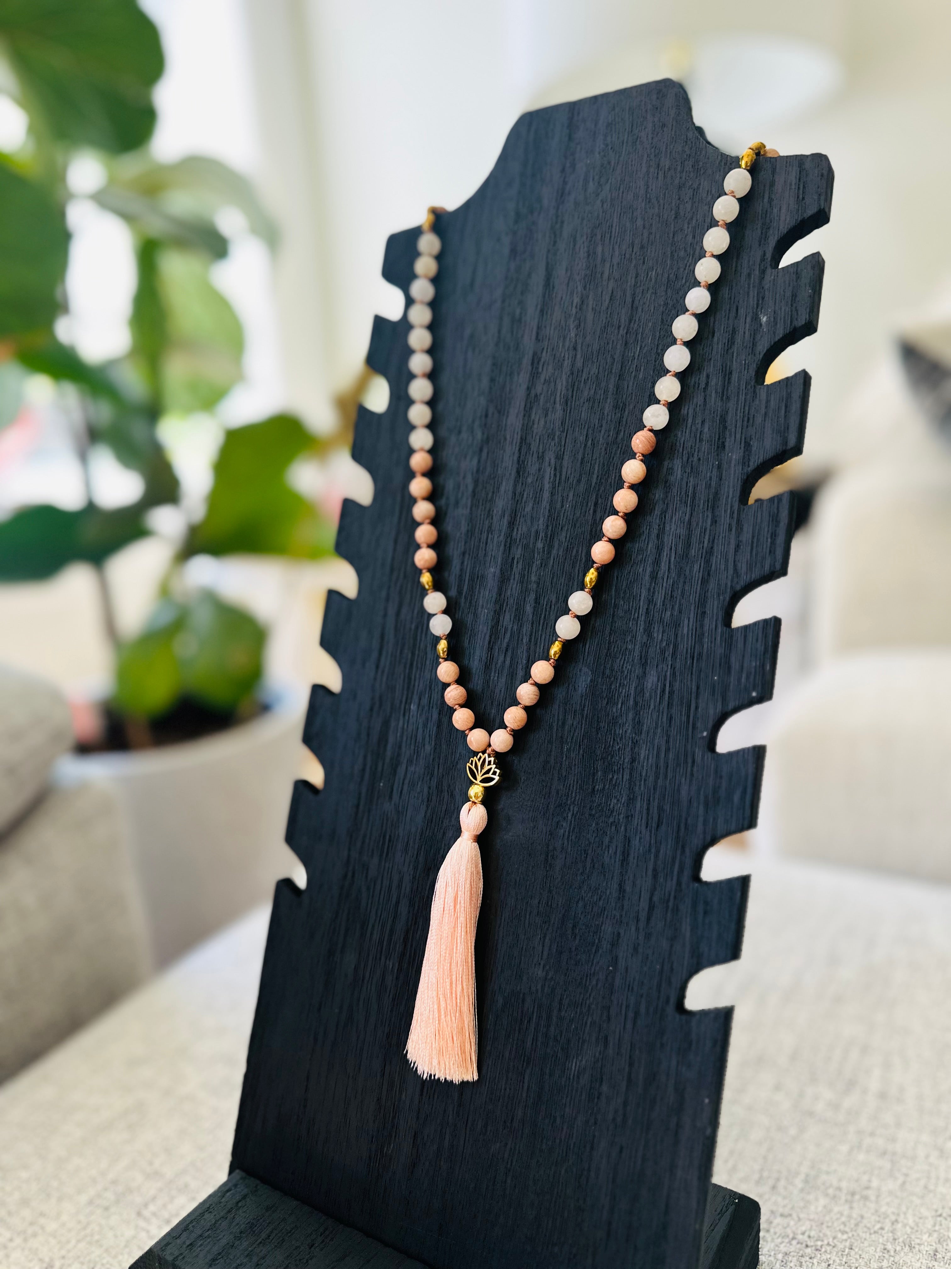 Serene Lotus Mala features Peach Moonstone for calm, Hematite for protection, and White Jade for peace, promoting spiritual growth