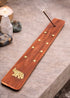 Elephant wooden incense holder with brass stars for meditation and incense rituals.