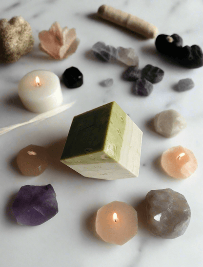 Serpentine Cube paired with candles, enhancing its soothing energy, ideal for clearing and rebalancing during meditation