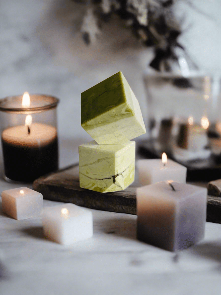 Serpentine Cube surrounded by candles, creating a calming ambiance, perfect for meditation and spiritual exploration