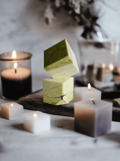 Serpentine Cube surrounded by candles, creating a calming ambiance, perfect for meditation and spiritual exploration