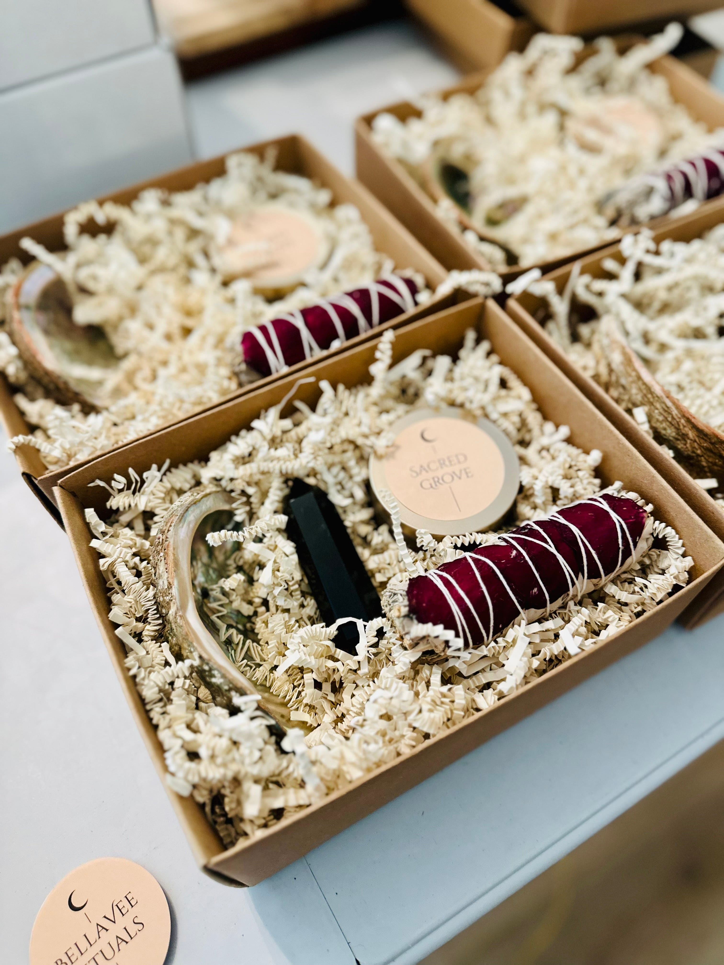 Flat lay of three mini ritual kits in a row, each with unique components arranged in eco-friendly filler.