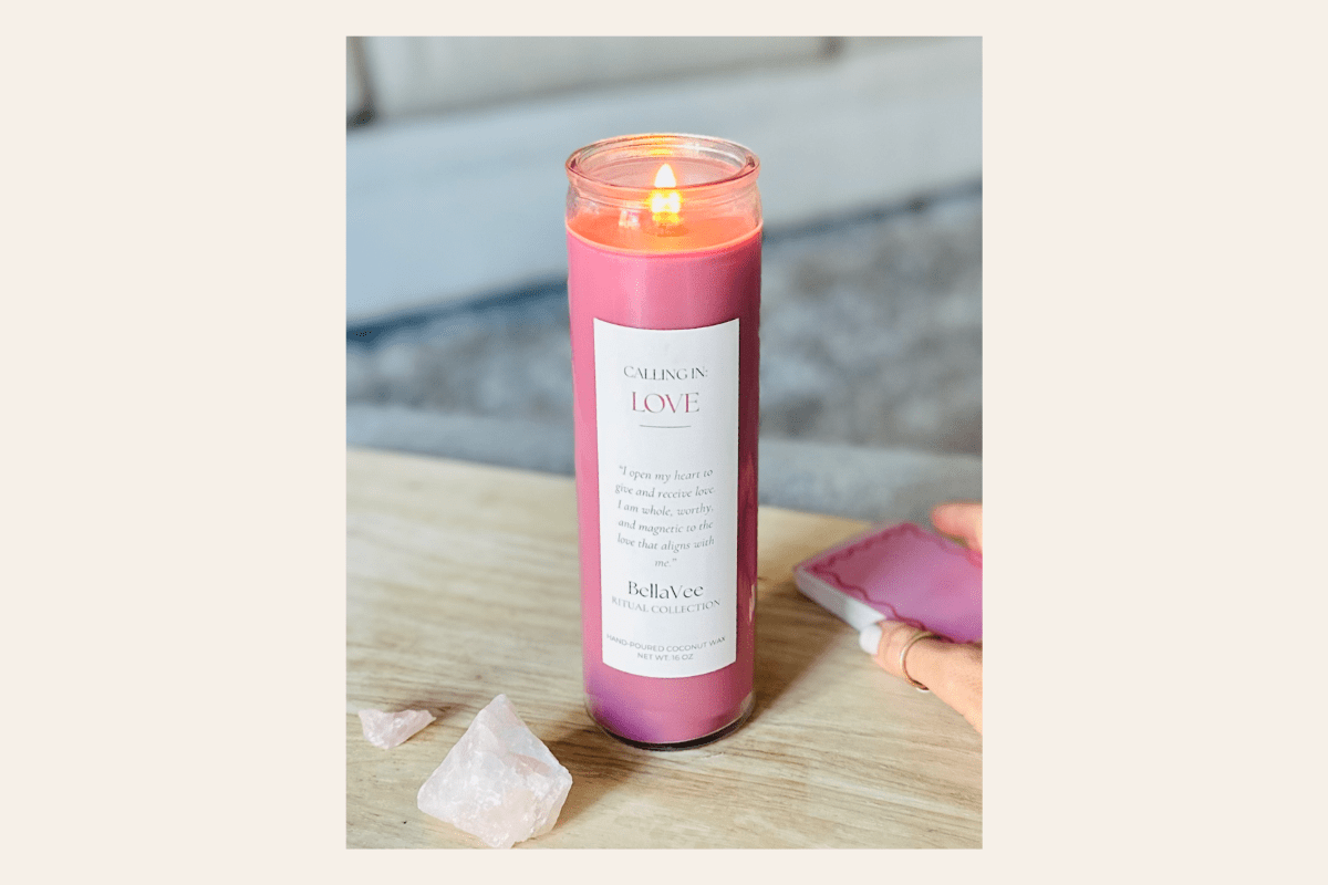Tall Pink candle with a label on a wooden surface