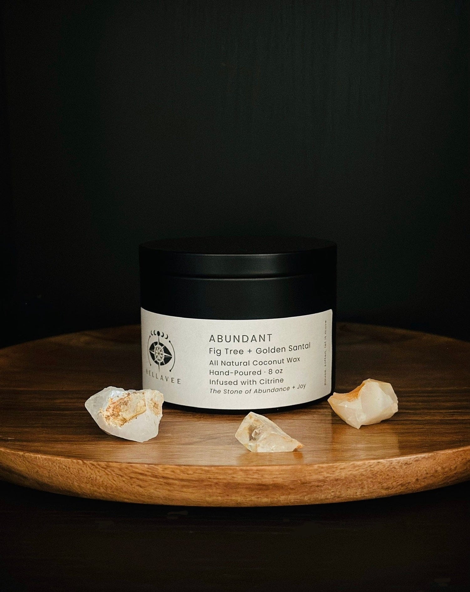 Abundant Citrine crystal candle tin representing abundance and prosperity, on wooden plate surrounded by crystals.