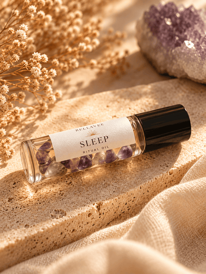 BellaVee SLEEP Ritual Oil roll-on with amethyst chips, displayed upright on natural stone with warm golden lighting and soft botanical accents.