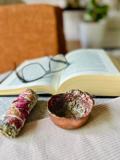 Copper bowl used in altar setup with dried herbs and candles