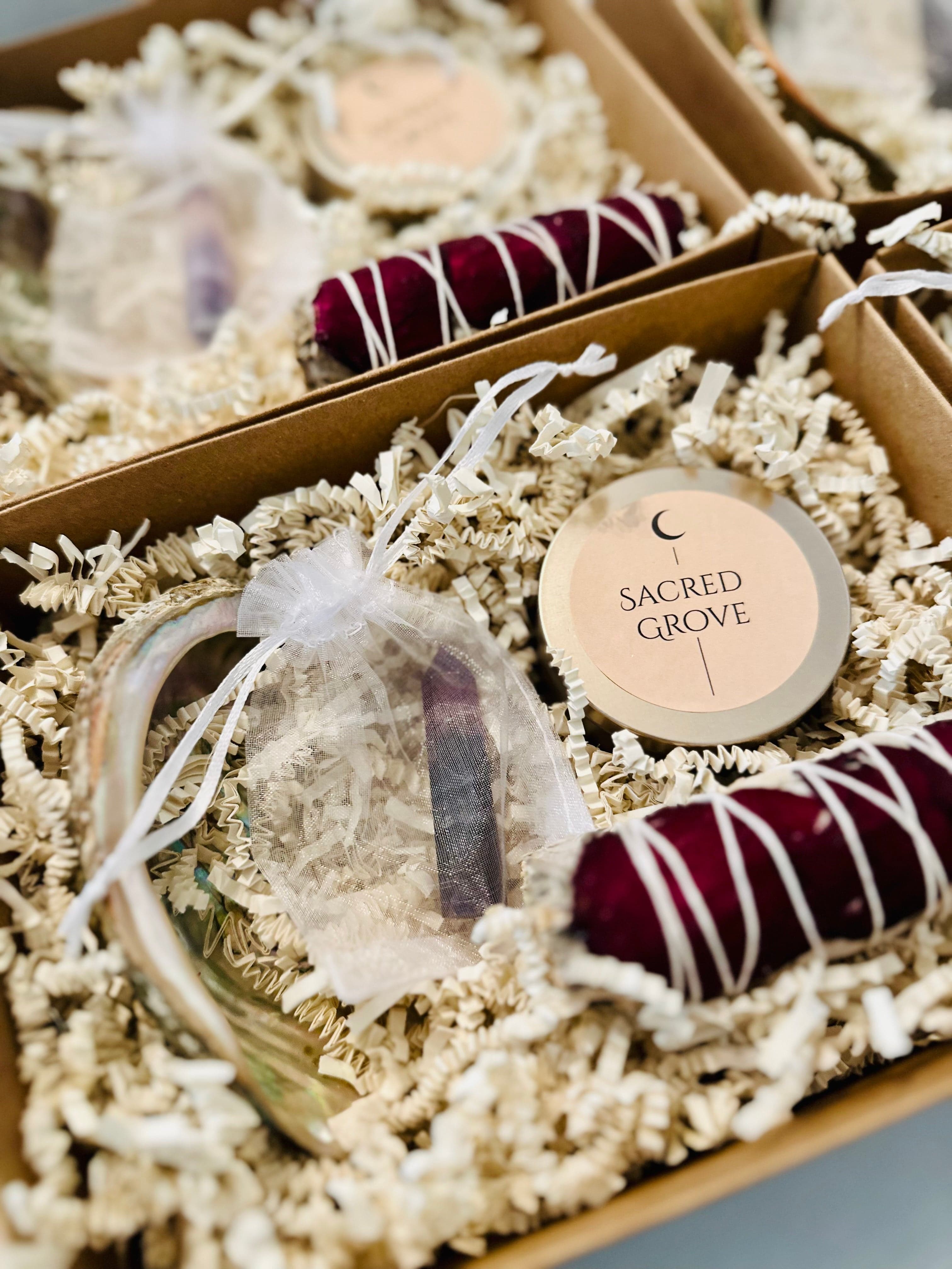 Gift box with a crystal ritual kit including a mini candle, sage, crystal point, and shell dish.