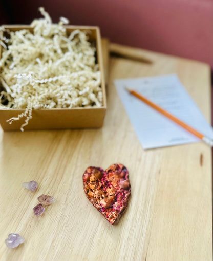 Flat lay of copper heart with journal, Palo Santo, and ritual tools