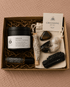 Grounding Ritual Kit with Anchor candle, grounding crystals, sage, palo santo, perfume oil, and cotton pouch in a kraft gift box.