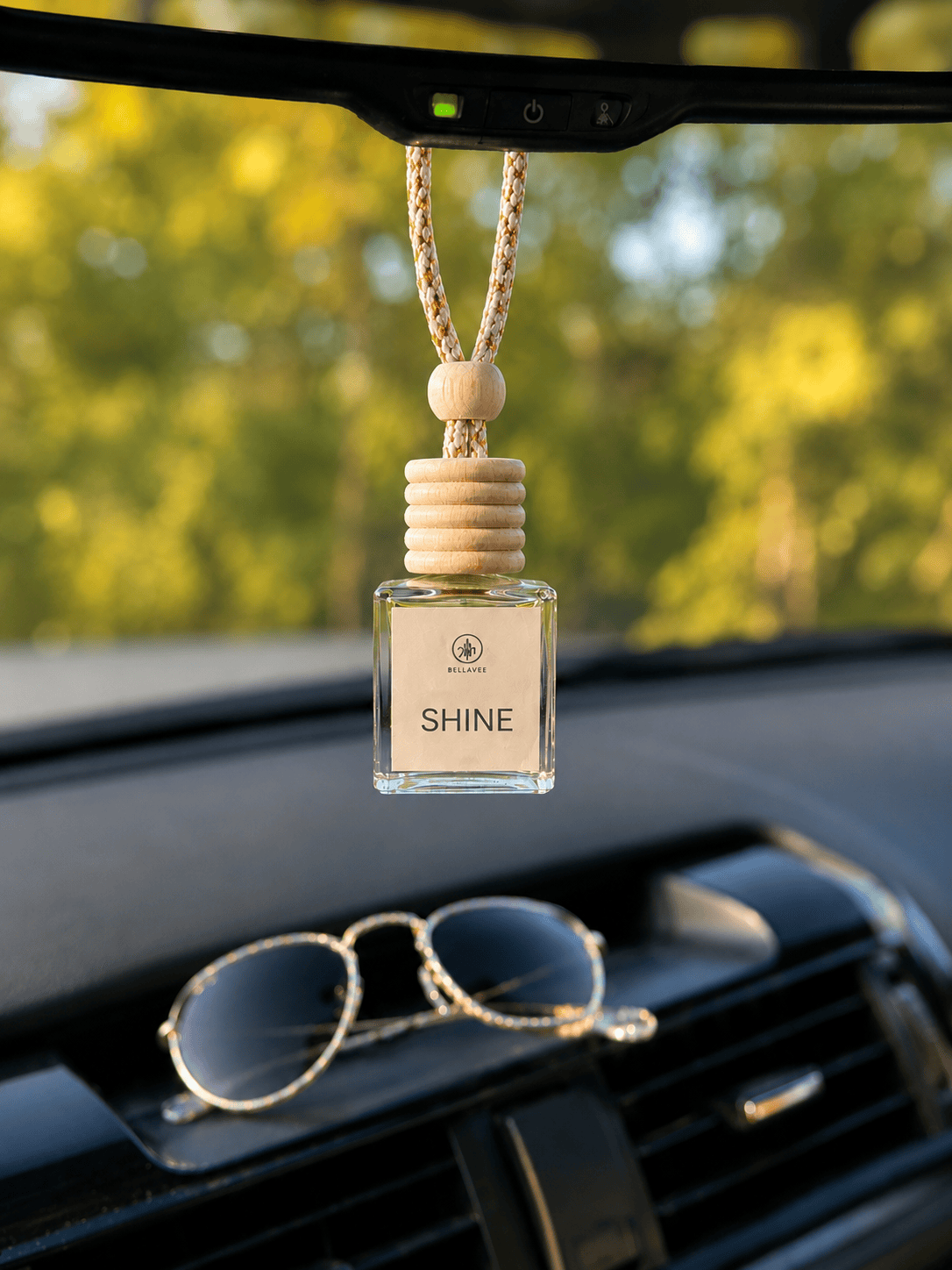 Sunwashed non-toxic car diffuser by BellaVee, hanging from rearview mirror
