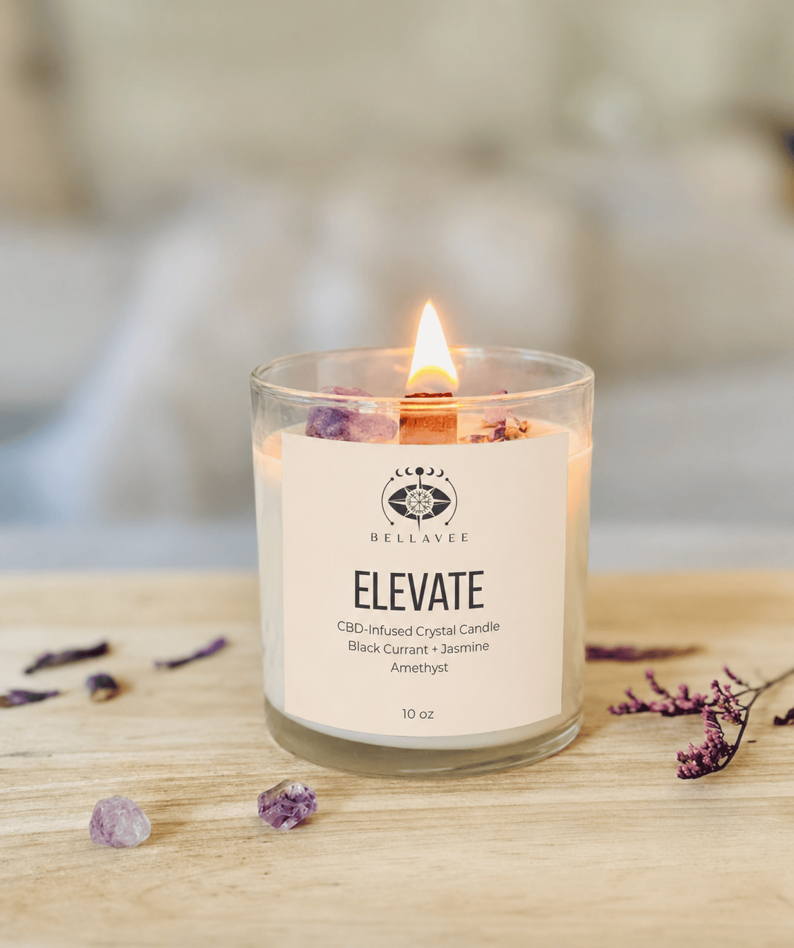 BellaVee ELEVATE CBD-infused crystal candle with black currant and jasmine fragrance, amethyst crystal, and wooden wick burning in a calming home setting.