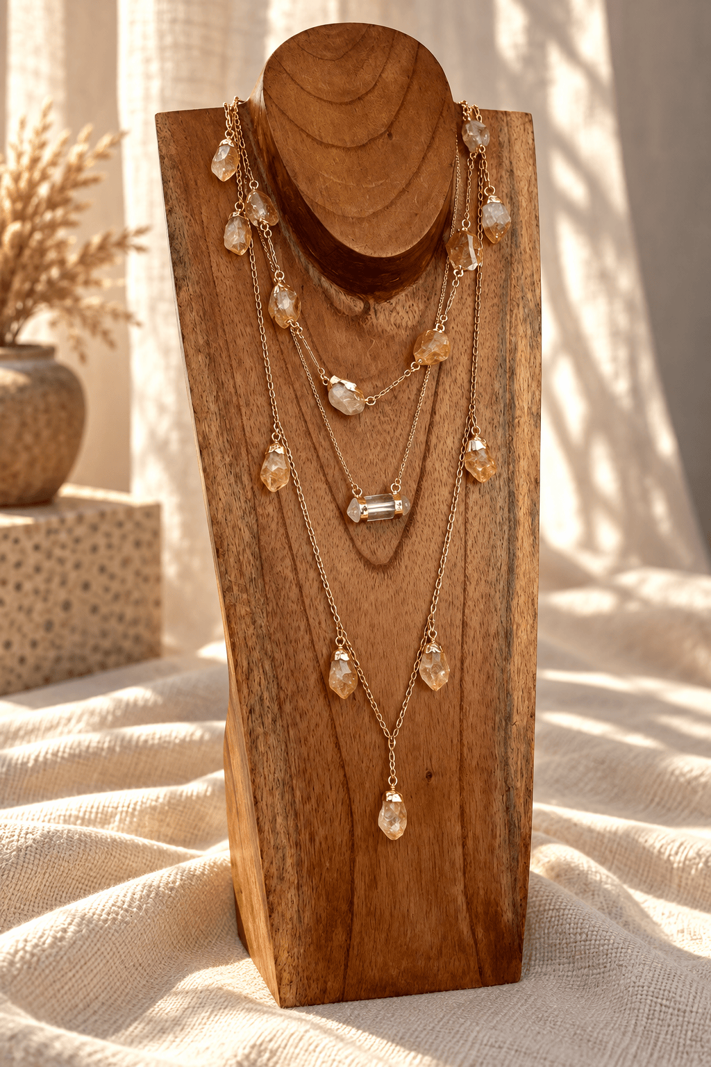Seven-stone Citrine necklace doubled into a layered gold crystal necklace on wooden jewelry stand