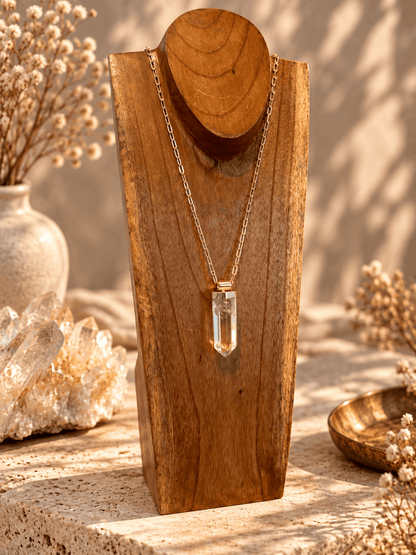 Large Clear Quartz crystal pendant necklace on adjustable gold open-link chain displayed on wooden jewelry 