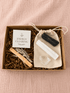 BellaVee Energy Clearing Ritual Kit featuring selenite, black tourmaline, clear quartz, palo santo, white sage, and a guided ritual card in a kraft gift box.