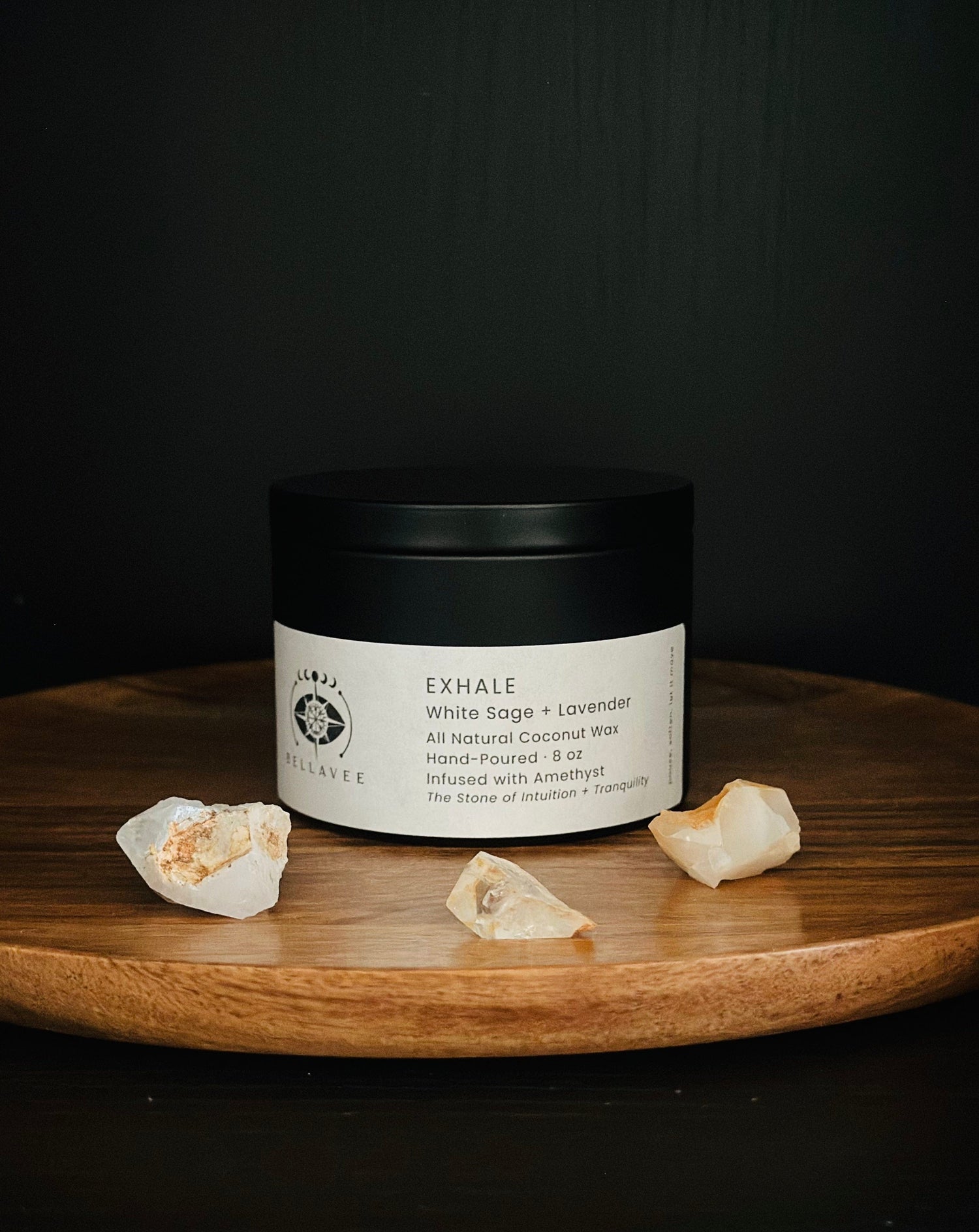 Exhale Amethyst crystal candle tin for calming and relaxation rituals, on wooden tray with crystals and dark background.