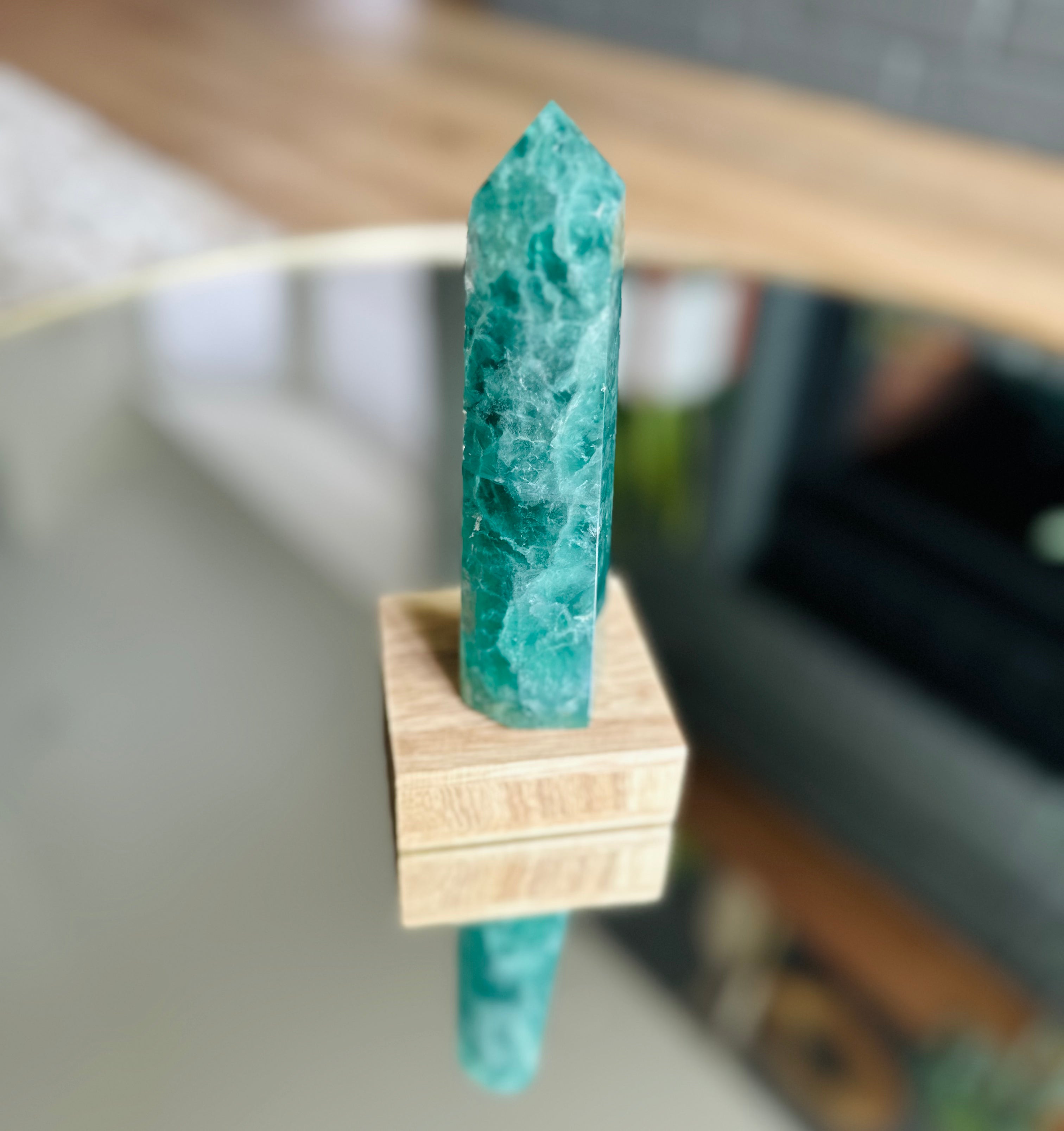 Green Fluorite tower with multi-faceted surface, emits calming energy, enhances decision-making, and creates a serene atmosphere