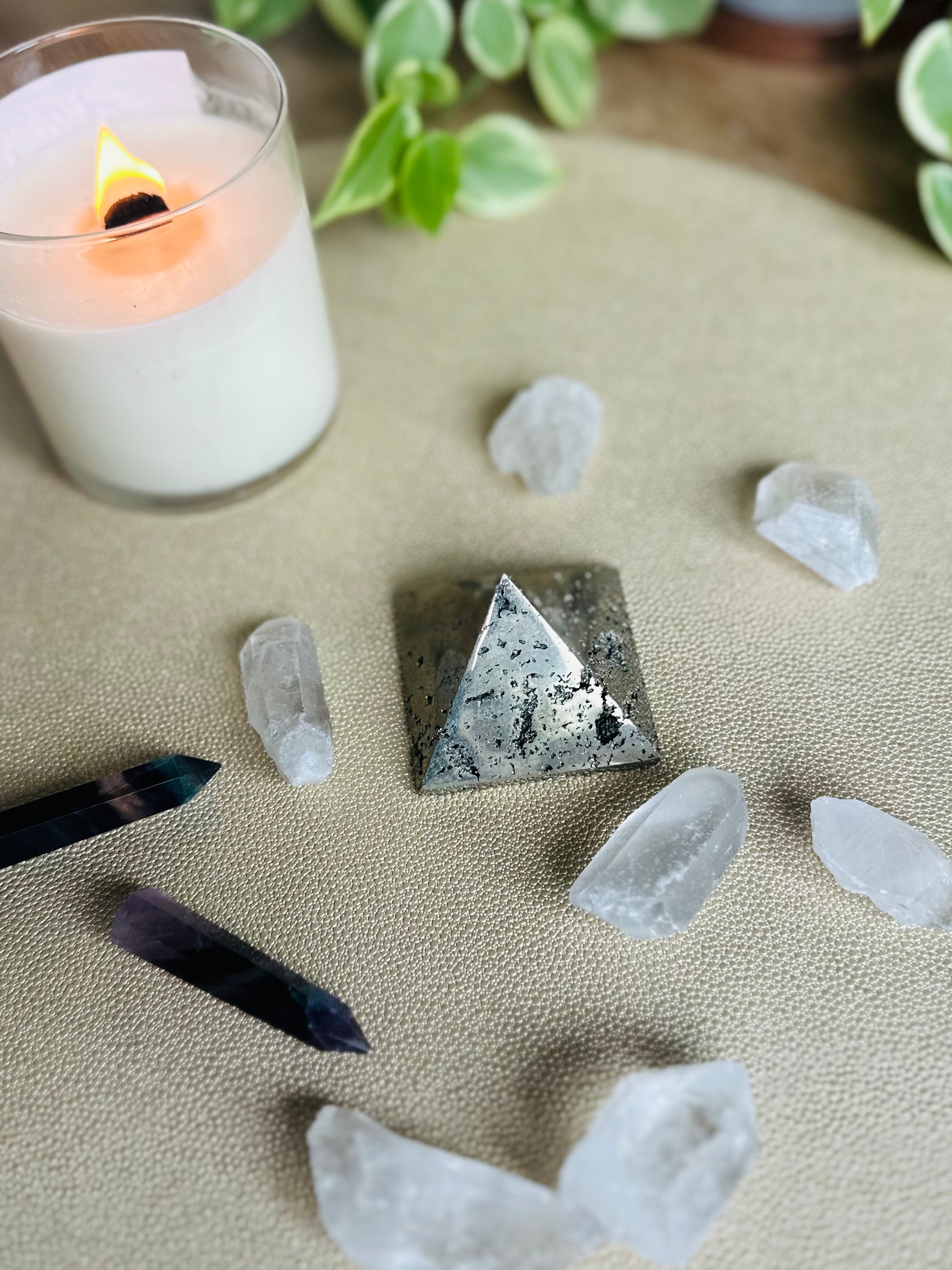 Pyrite Pyramid alongside crystals and candles boosts focus and positive energy for manifesting abundance and shielding negativity