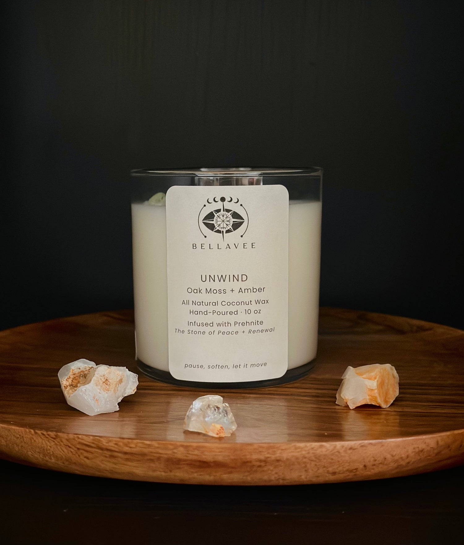 Unwind Prehnite crystal ritual candle in a clear glass jar styled on a wooden surface.