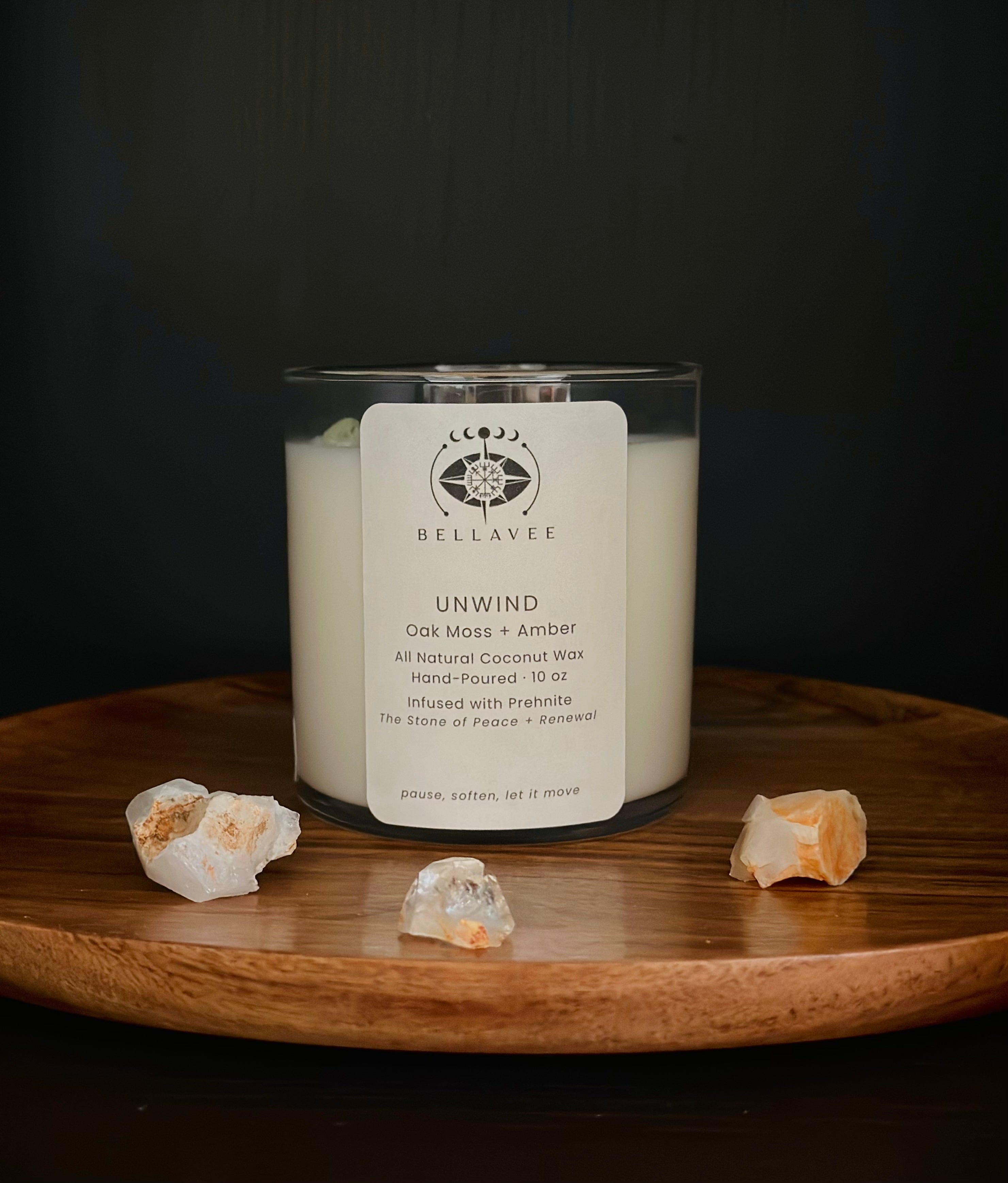 Unwind Prehnite crystal ritual candle in a clear glass jar styled on a wooden surface.