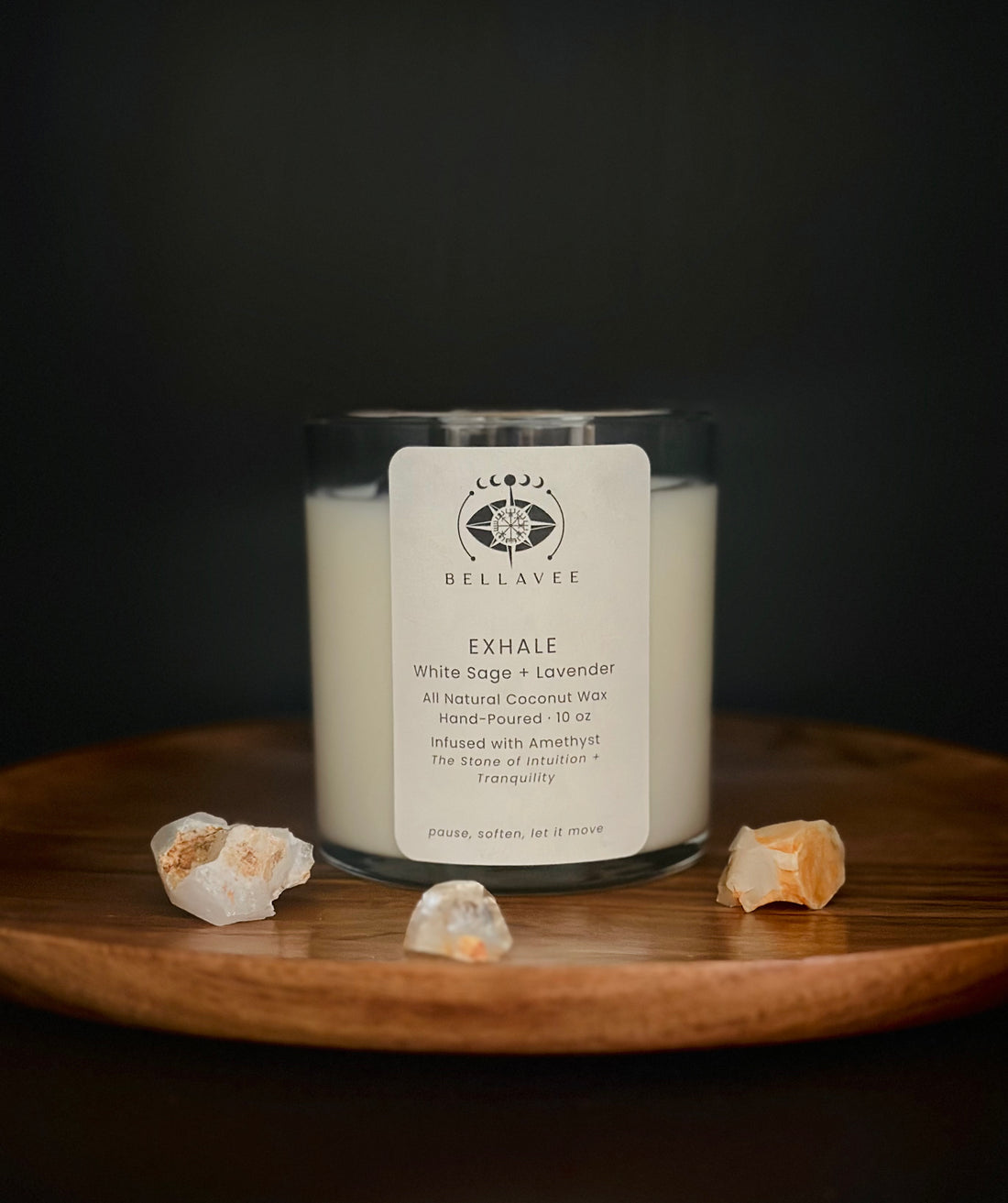 Exhale Amethyst crystal ritual candle in a glass vessel on a wooden tray with a calm, neutral setting.