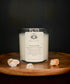 Transform Moonstone crystal ritual candle in a clear glass jar styled with natural elements.